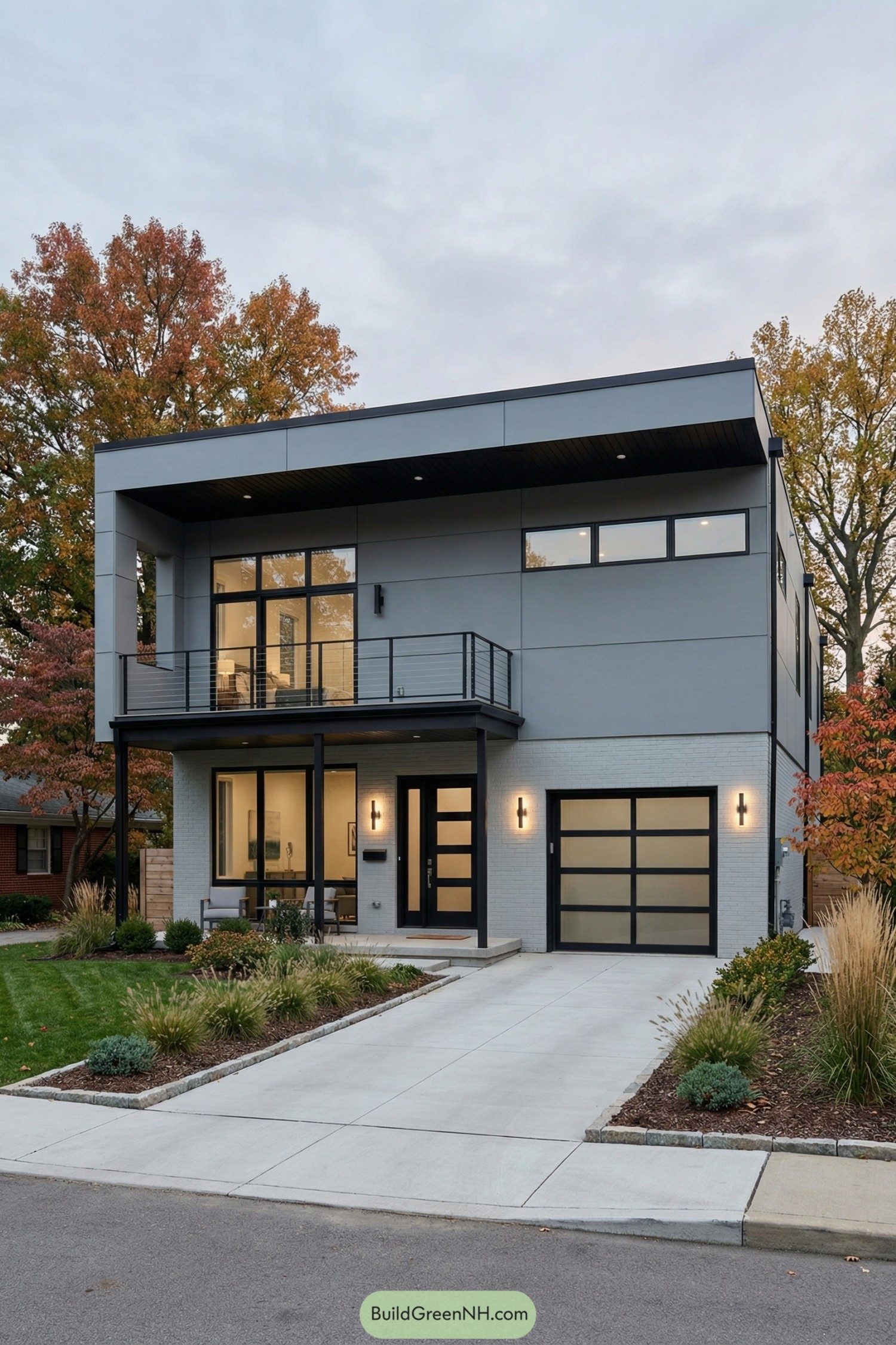 Two-story modern grey house with balcony and frosted glass garage door