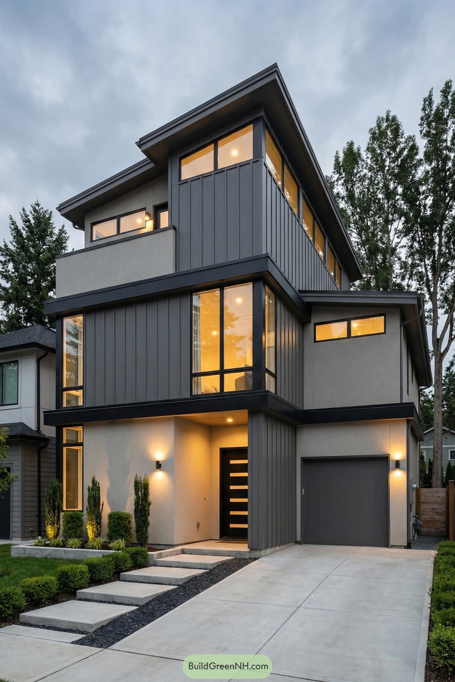 Three-story modern grey house with warm interior lighting