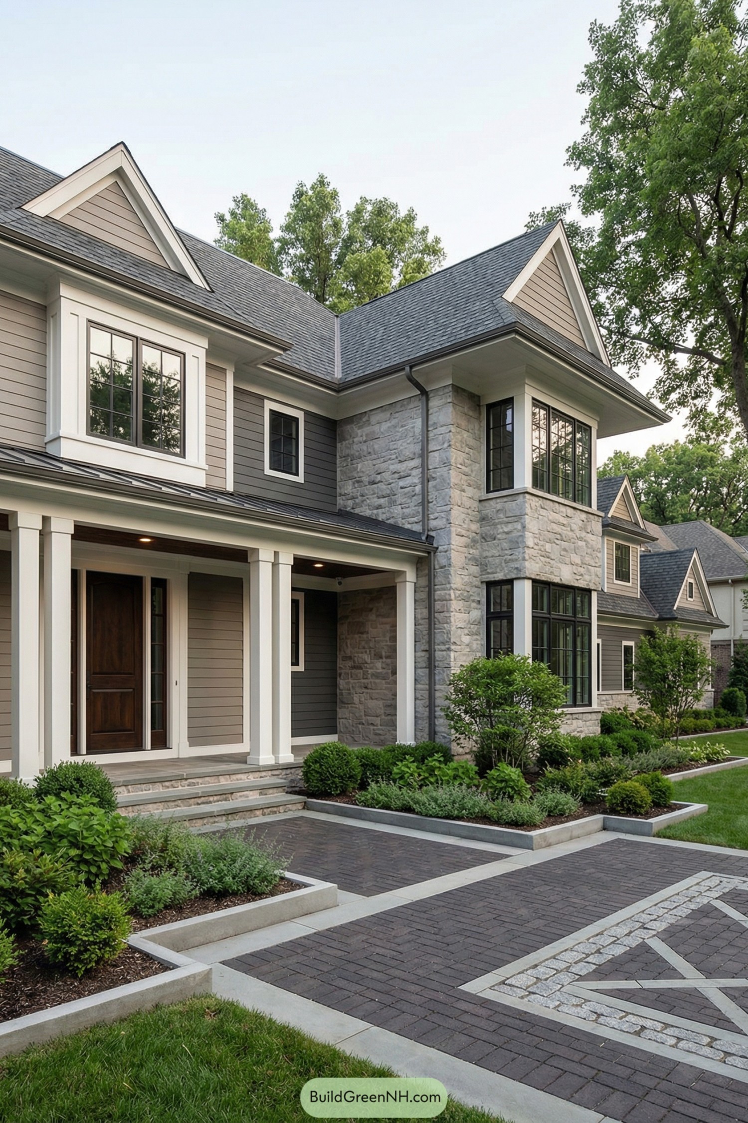 Modern gray house with patterned brick courtyard and manicured plant beds