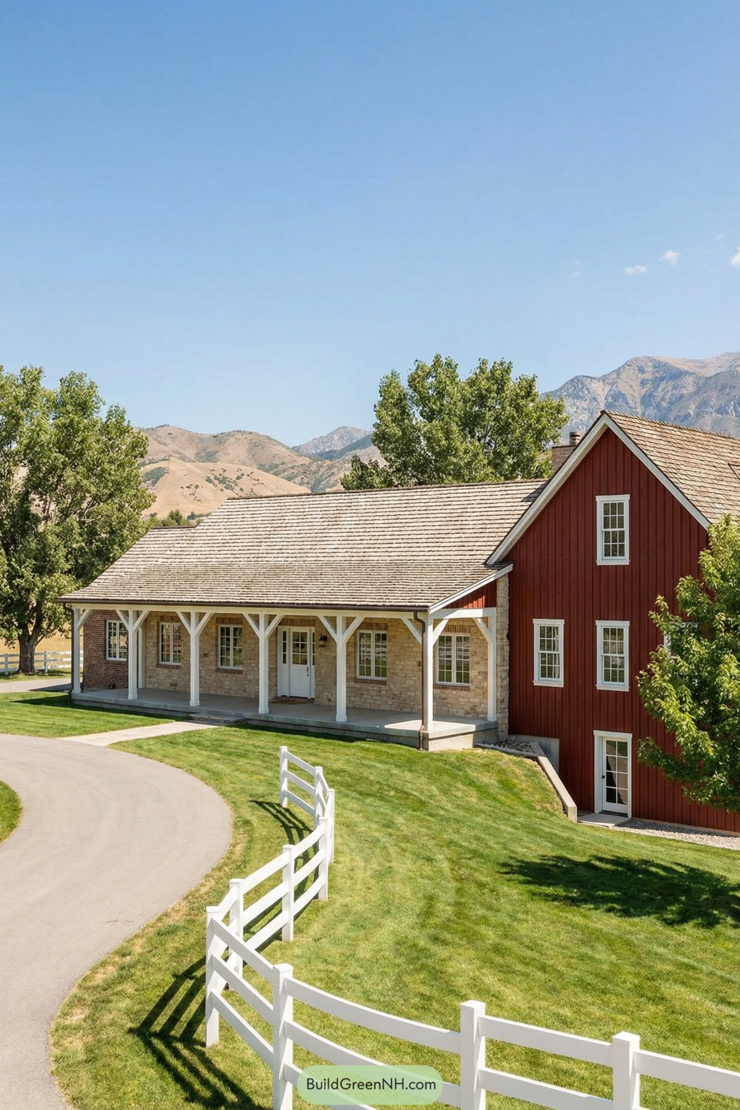 Red barn-style mountain ranch house with long stone porch and white fence