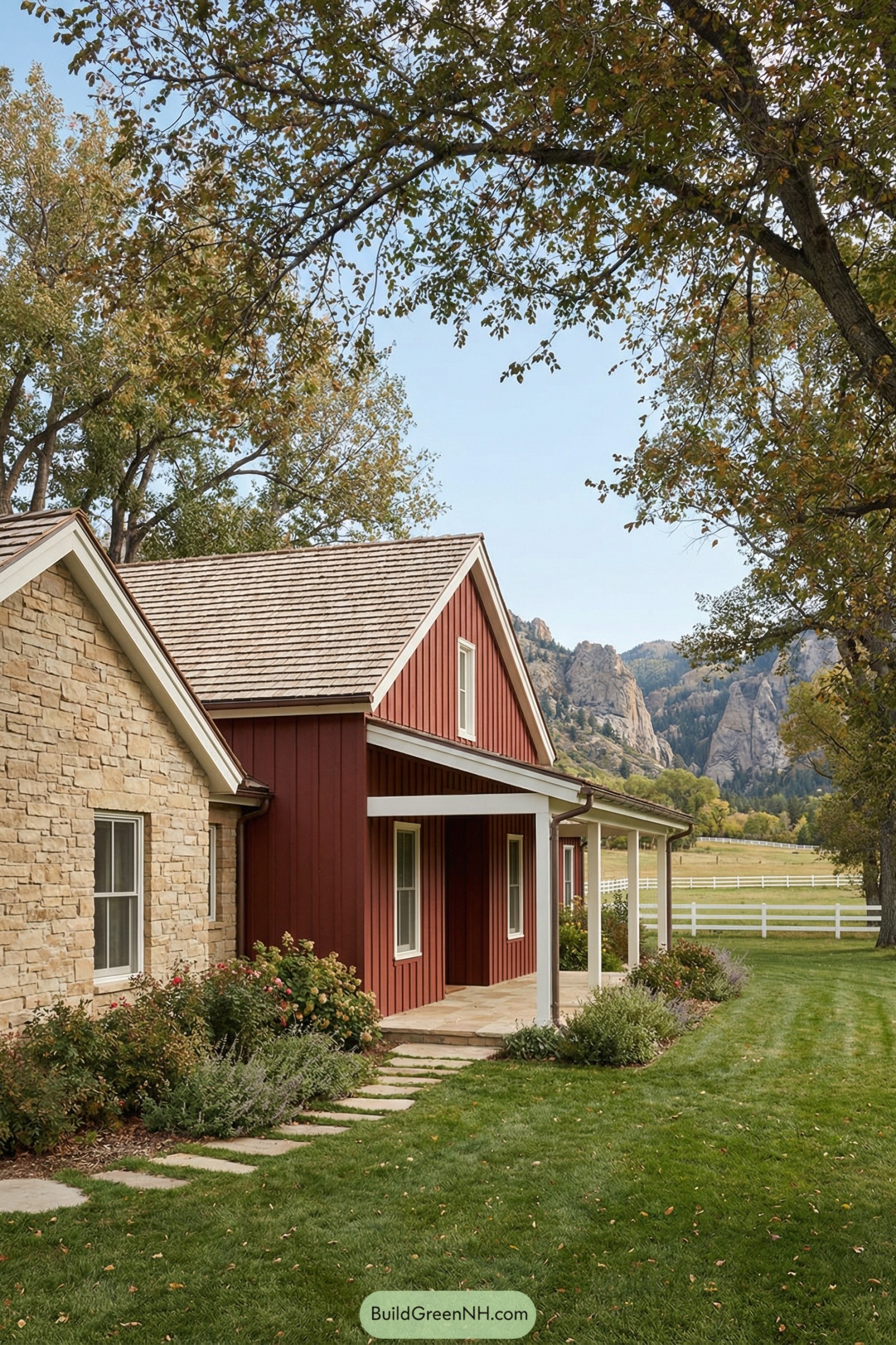 Red ranch-style farmhouse with stone wing and long porch set before distant rocky mountains