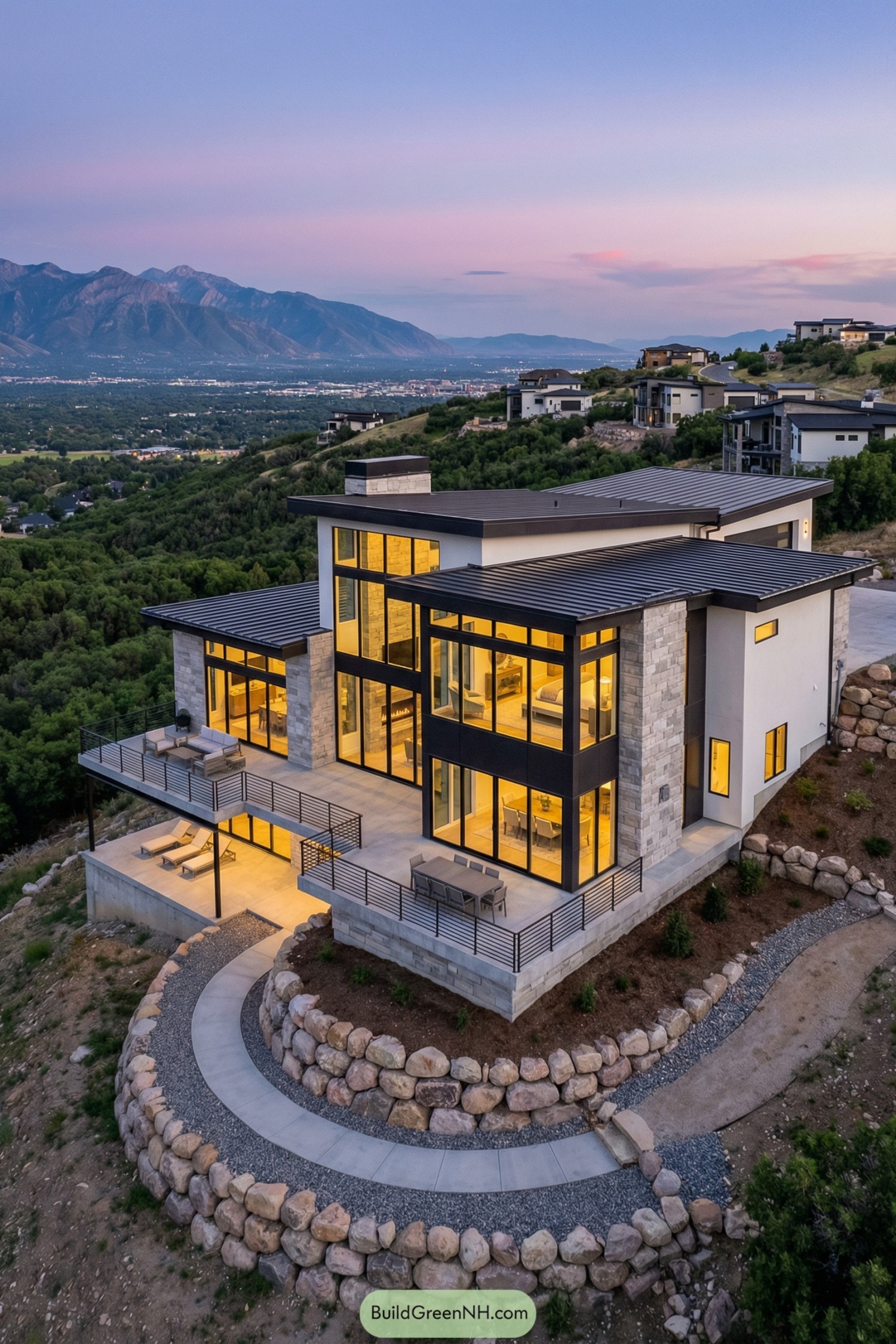 Modern hillside house with tiered decks and tall glass walls facing distant mountains