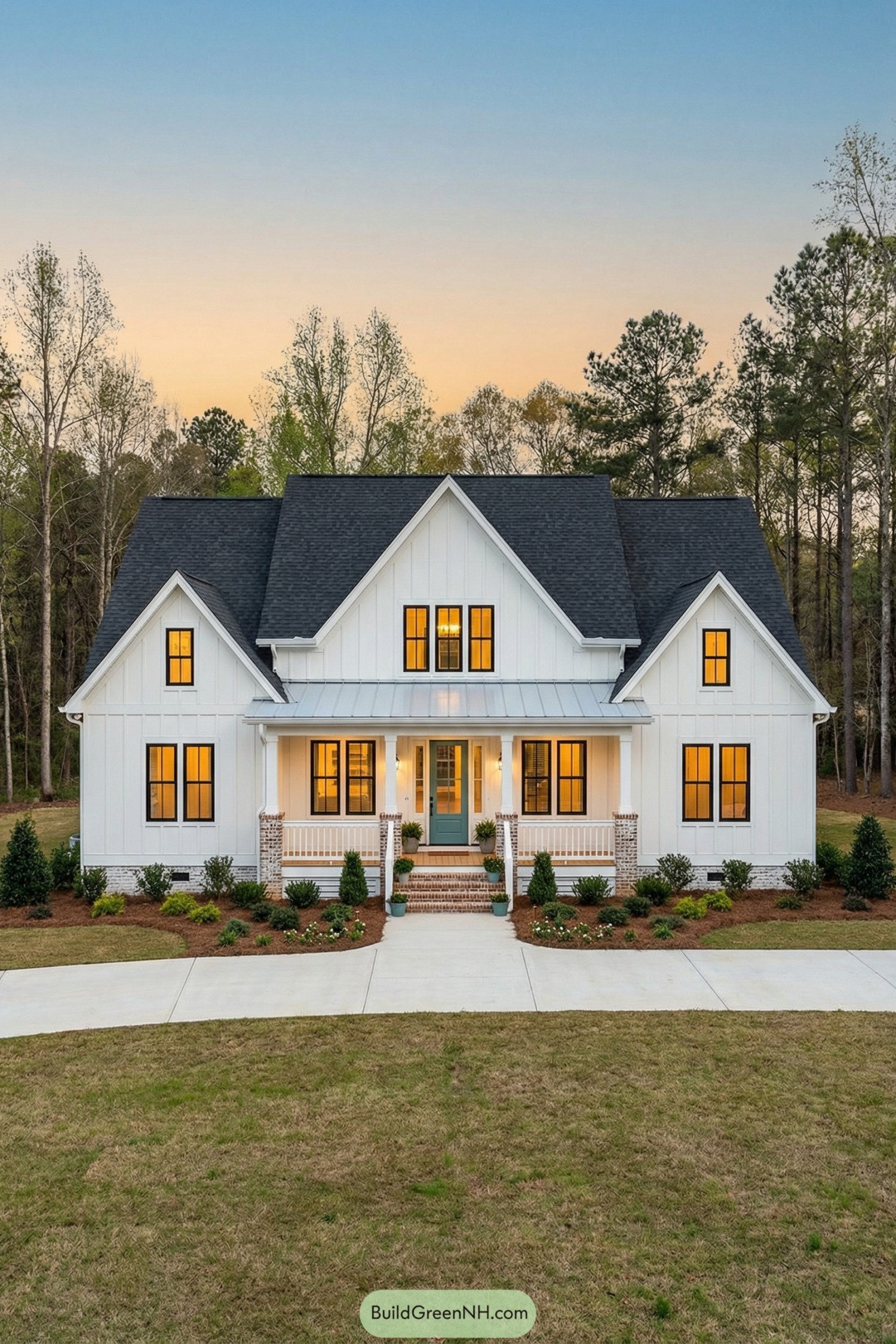 White farmhouse with tall gables and glowing windows at dusk