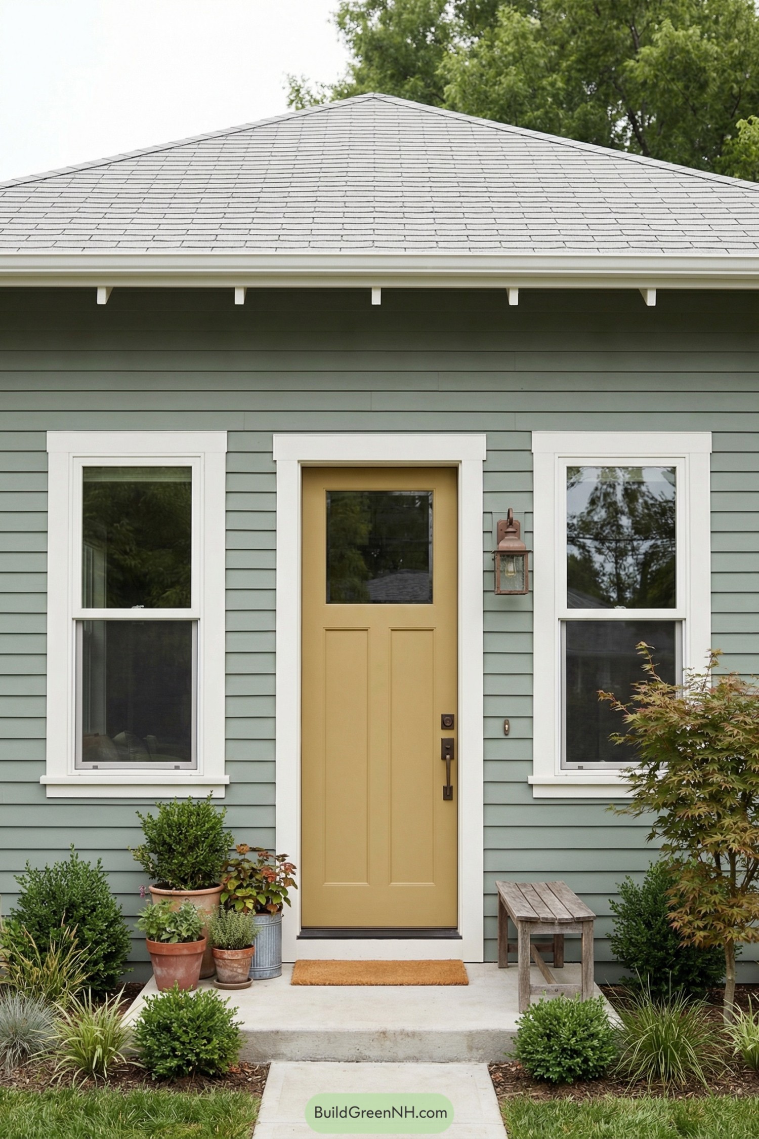 Sage green cottage front with mustard door