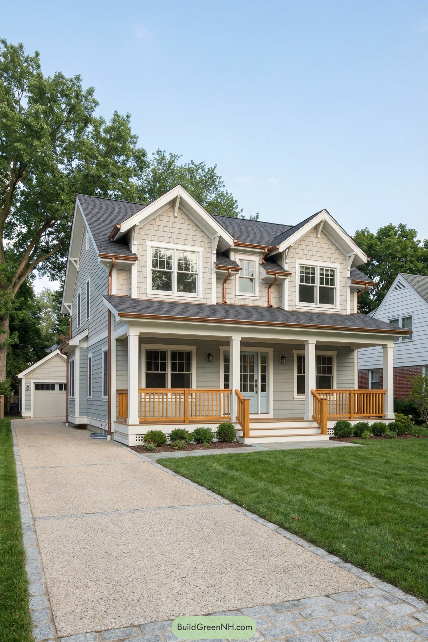 Two story gray cottage with wide front porch, white trim, and copper accents leading to a detached garage