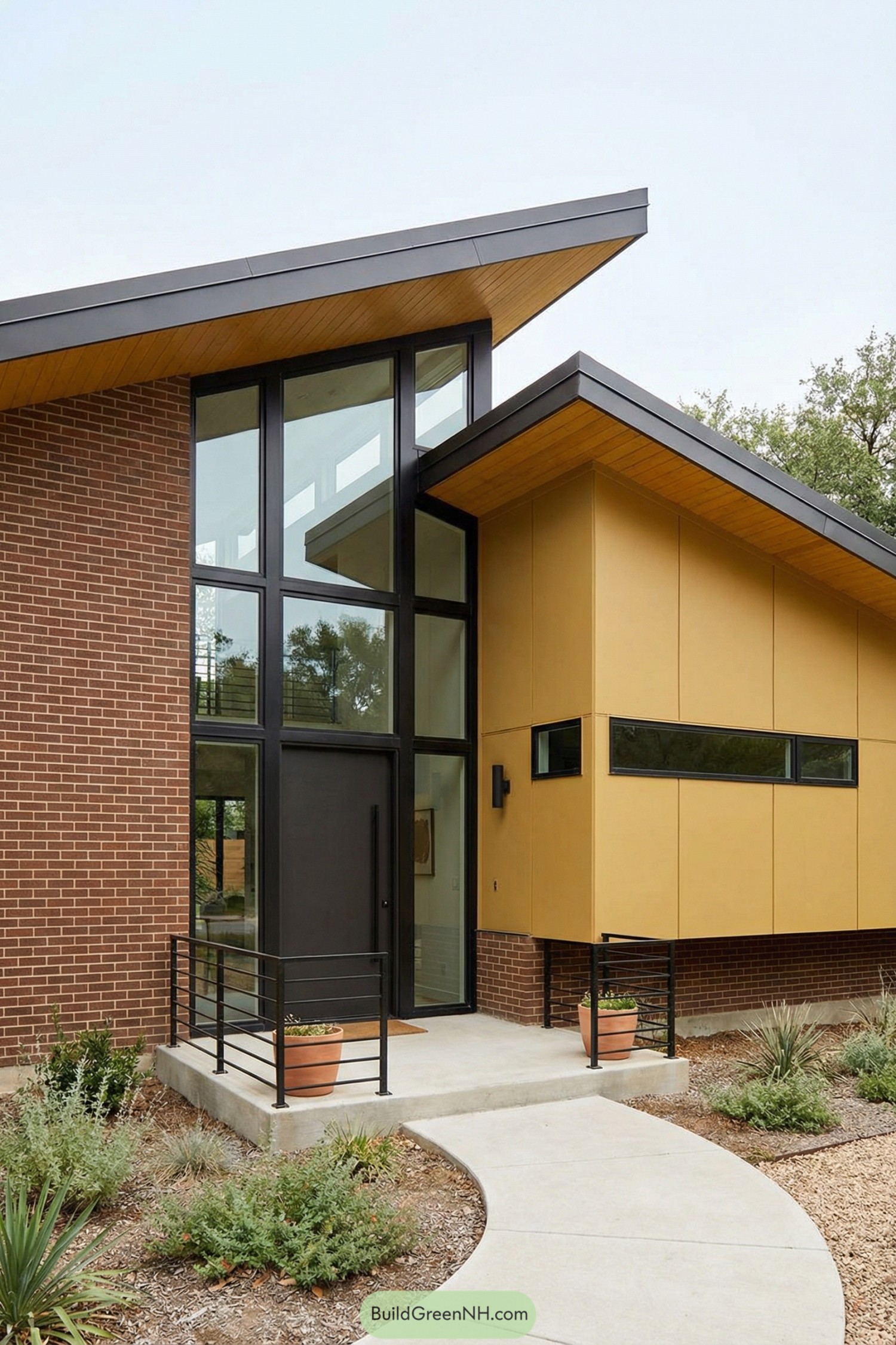 Midcentury inspired house with sloping rooflines, brick and mustard siding, and a tall glass front entry