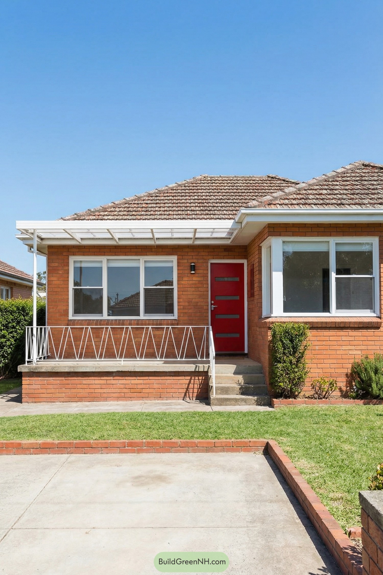 Single story brick house with bright red front door white trim and small covered porch