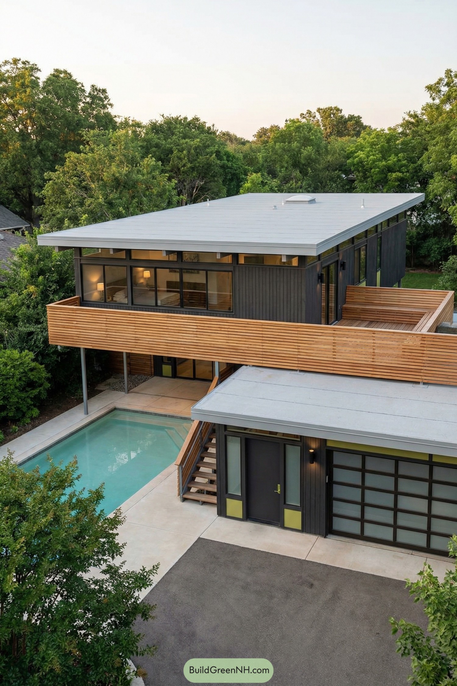 Modern two story midcentury style home with flat roofs overlooking a narrow backyard pool and wrapped in horizontal wood slats
