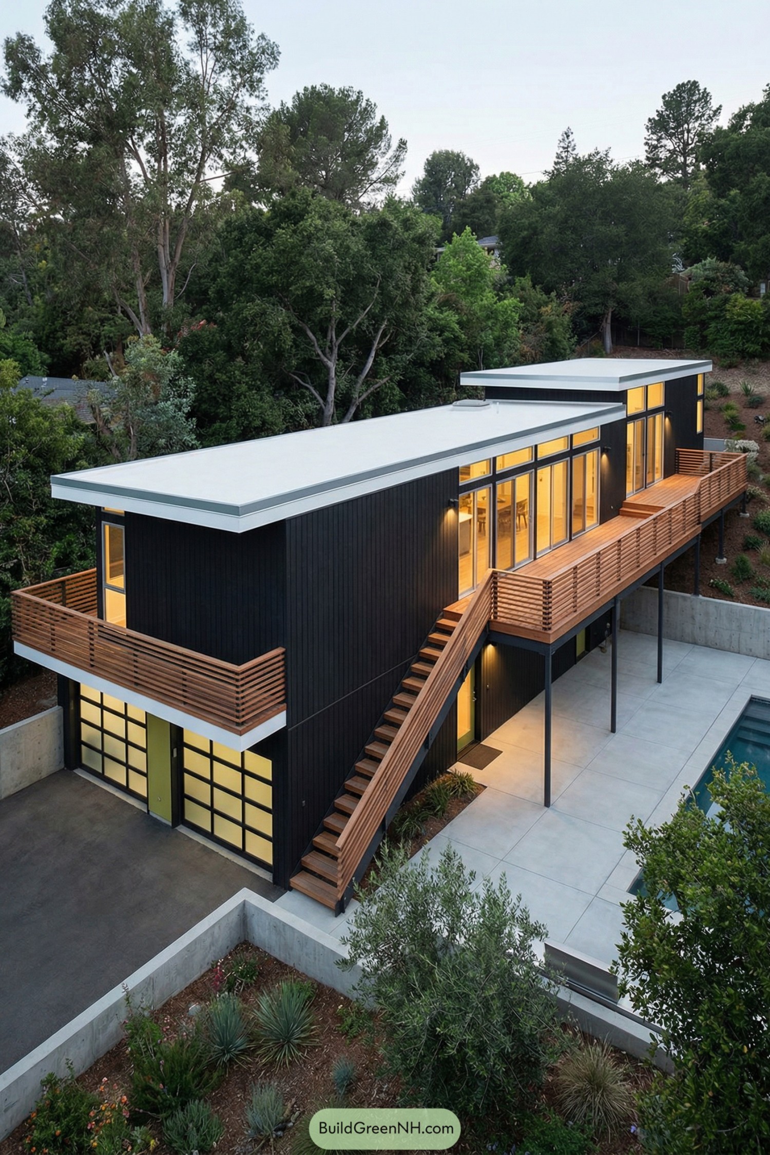 Modern black box house with long wood balcony overlooking pool and trees