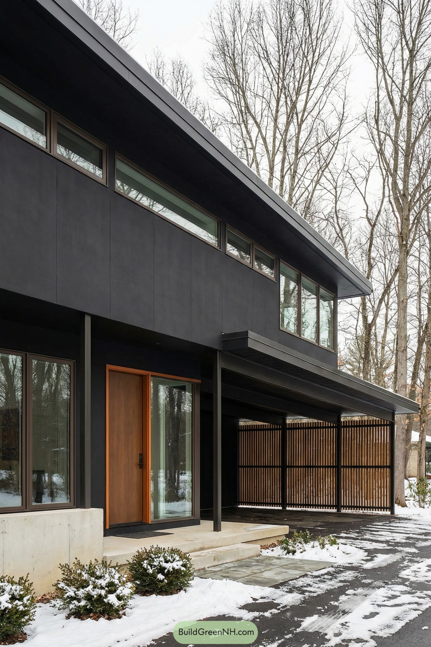 Black mid century modern house with long overhang, wood front door, and slatted cedar carport in a snowy setting