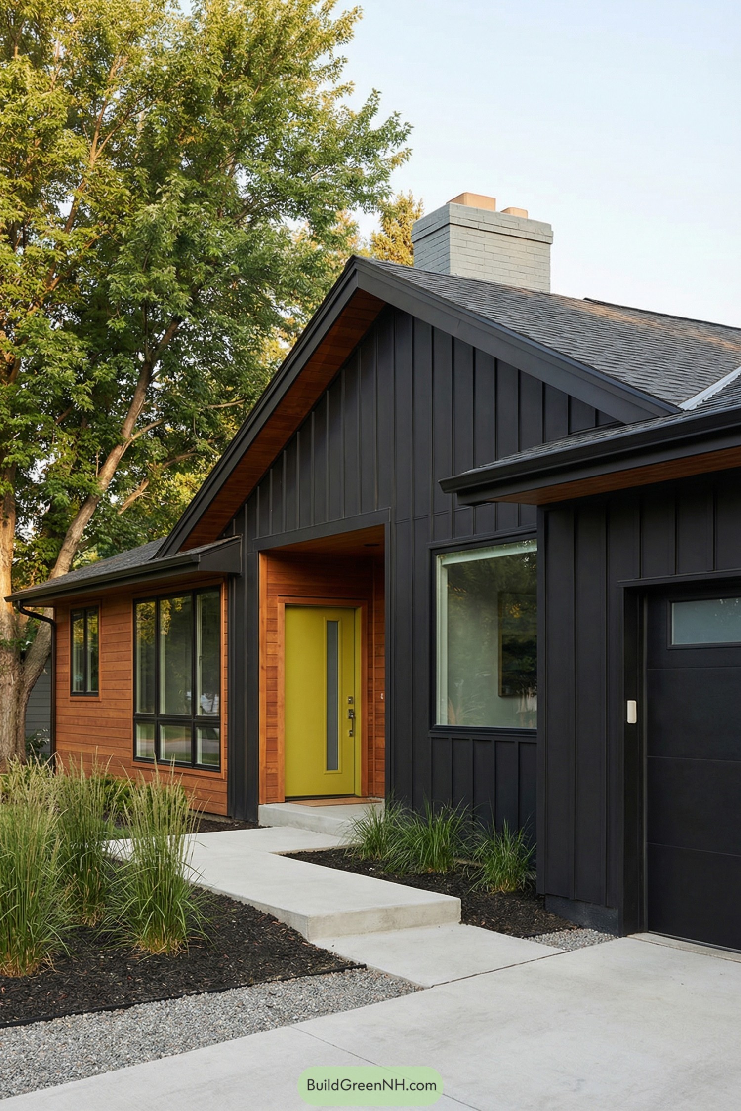 Modern black and wood house with bright olive front door and simple concrete walkway