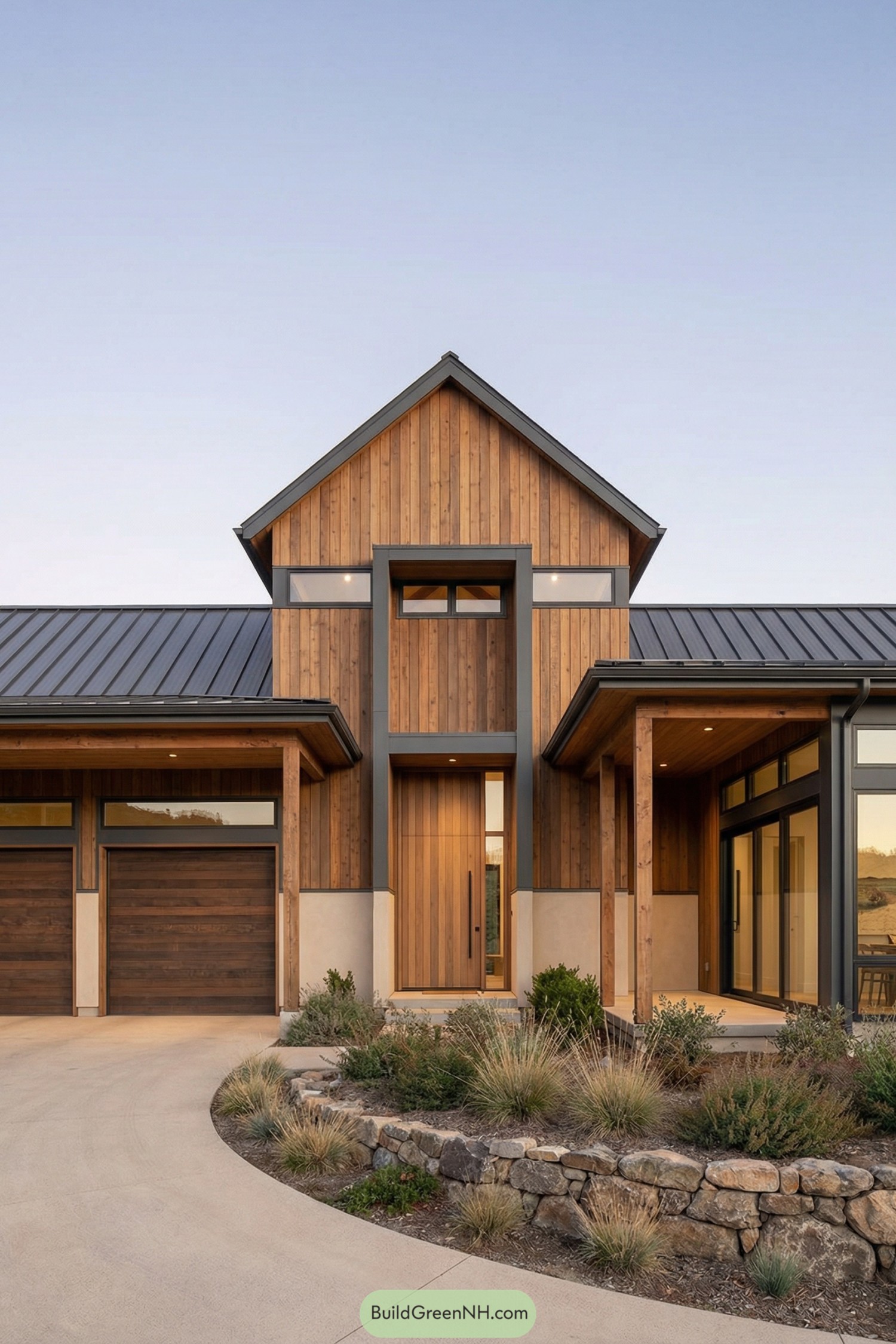 Modern wood clad home with tall central gable and glass lined entry