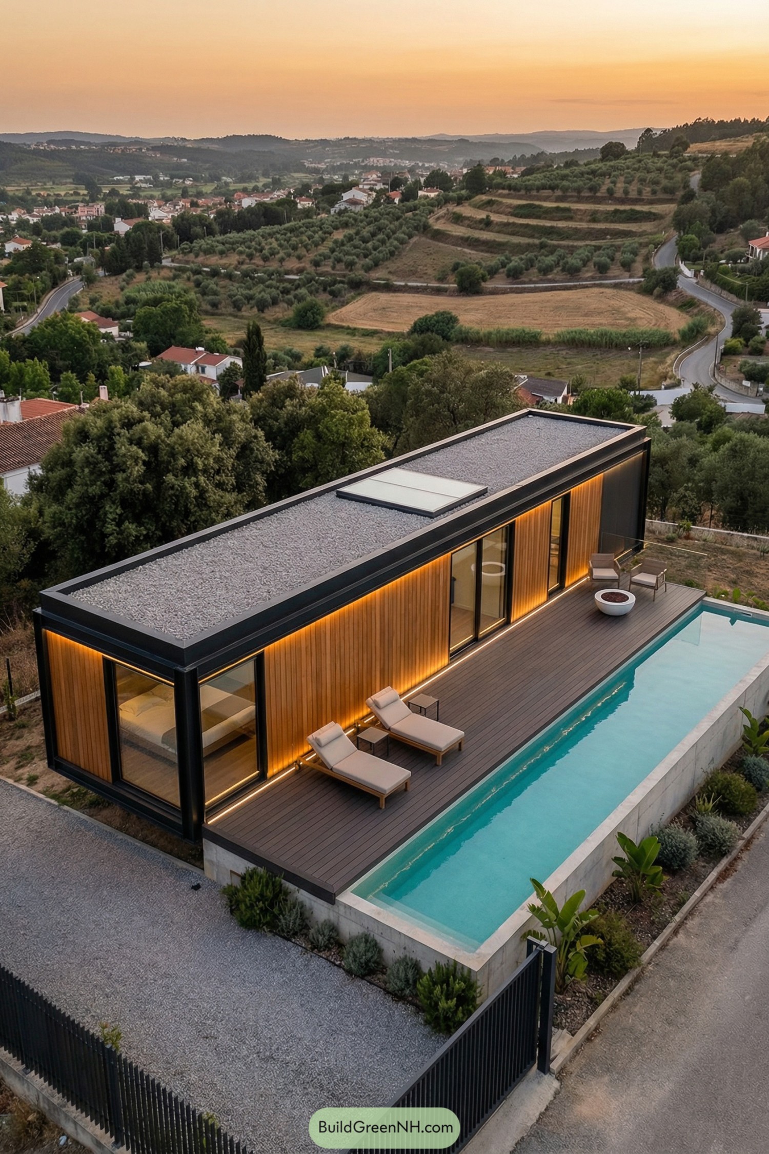 Modern container home with wood cladding, long deck, and narrow lap pool overlooking rolling countryside