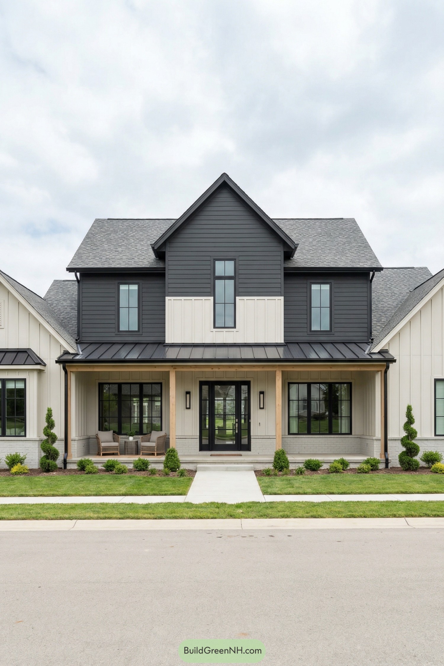 Modern two story farmhouse with dark central volume flanked by light siding and a wide front porch