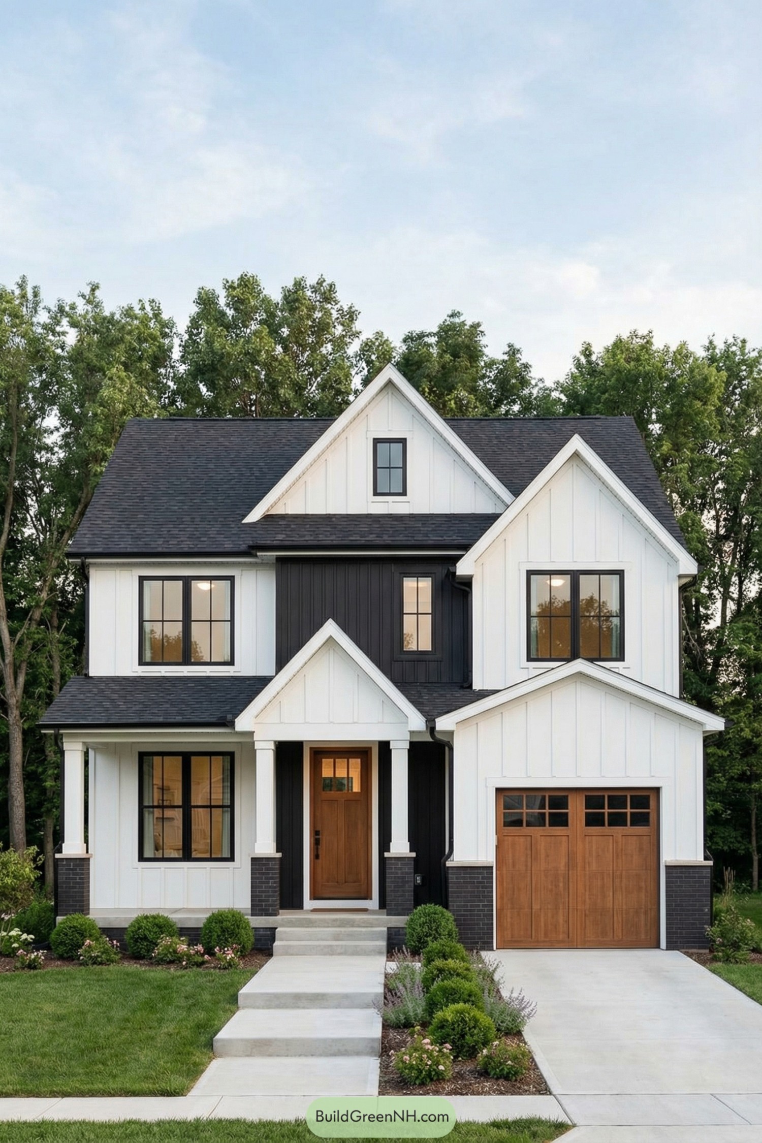 White two story modern farmhouse with black accents and warm wood doors