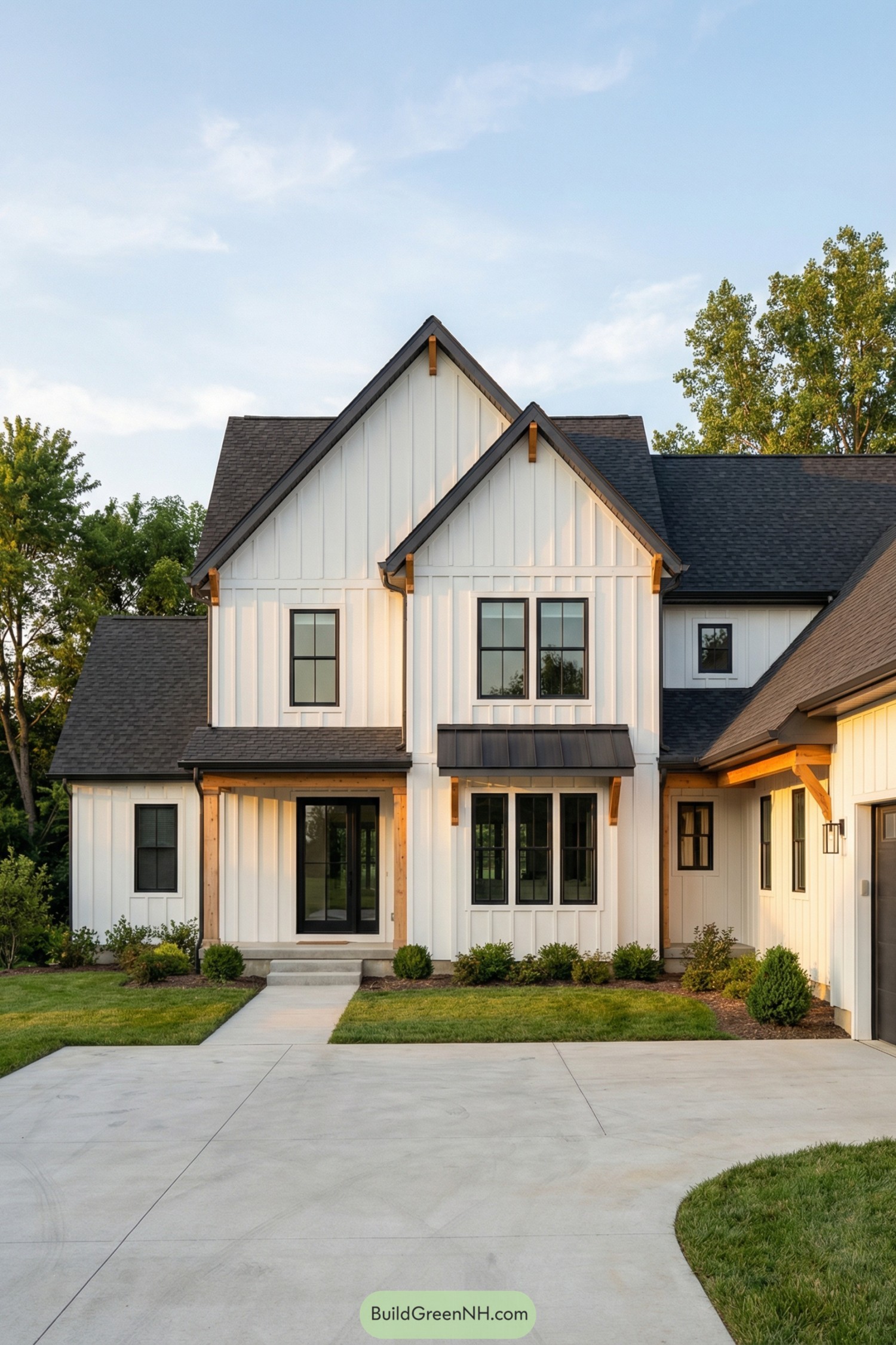 White modern farmhouse with black roof and wood accents at sunset