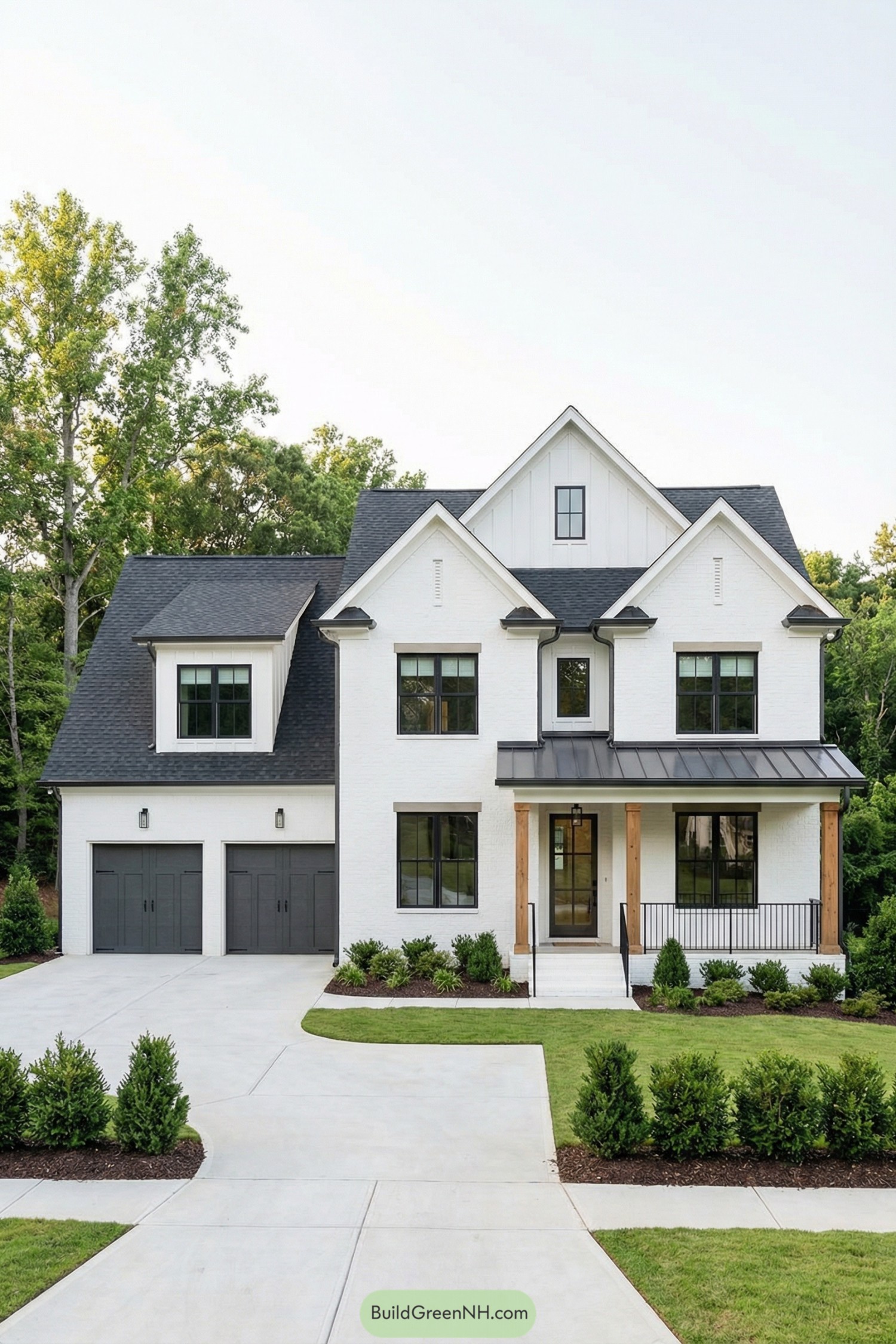 Two story white brick house with black roof and attached double garage