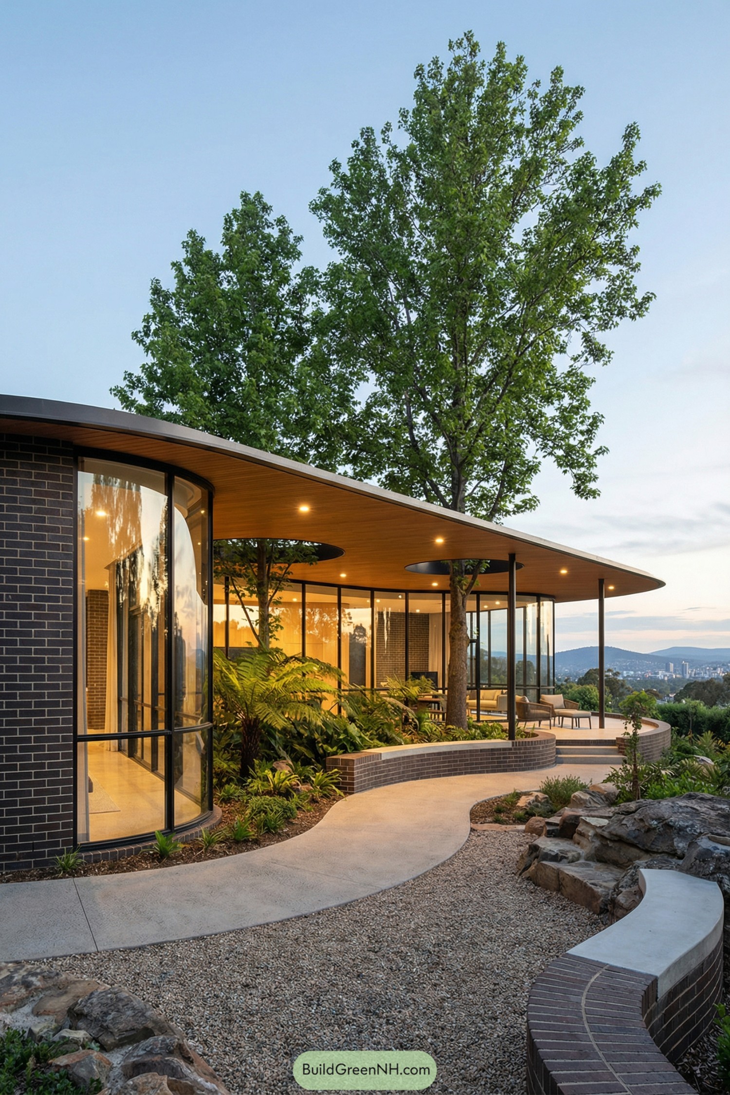 Curved glass pavilion house with trees