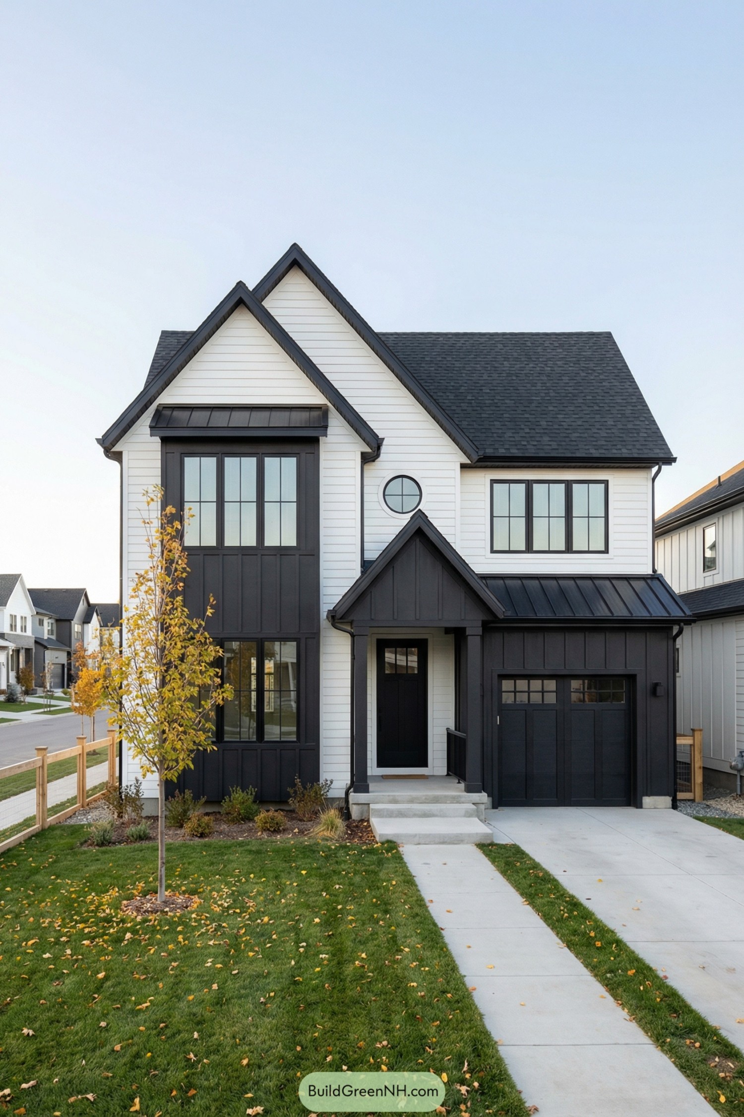 Black and white modern two story house with gabled roof and attached garage