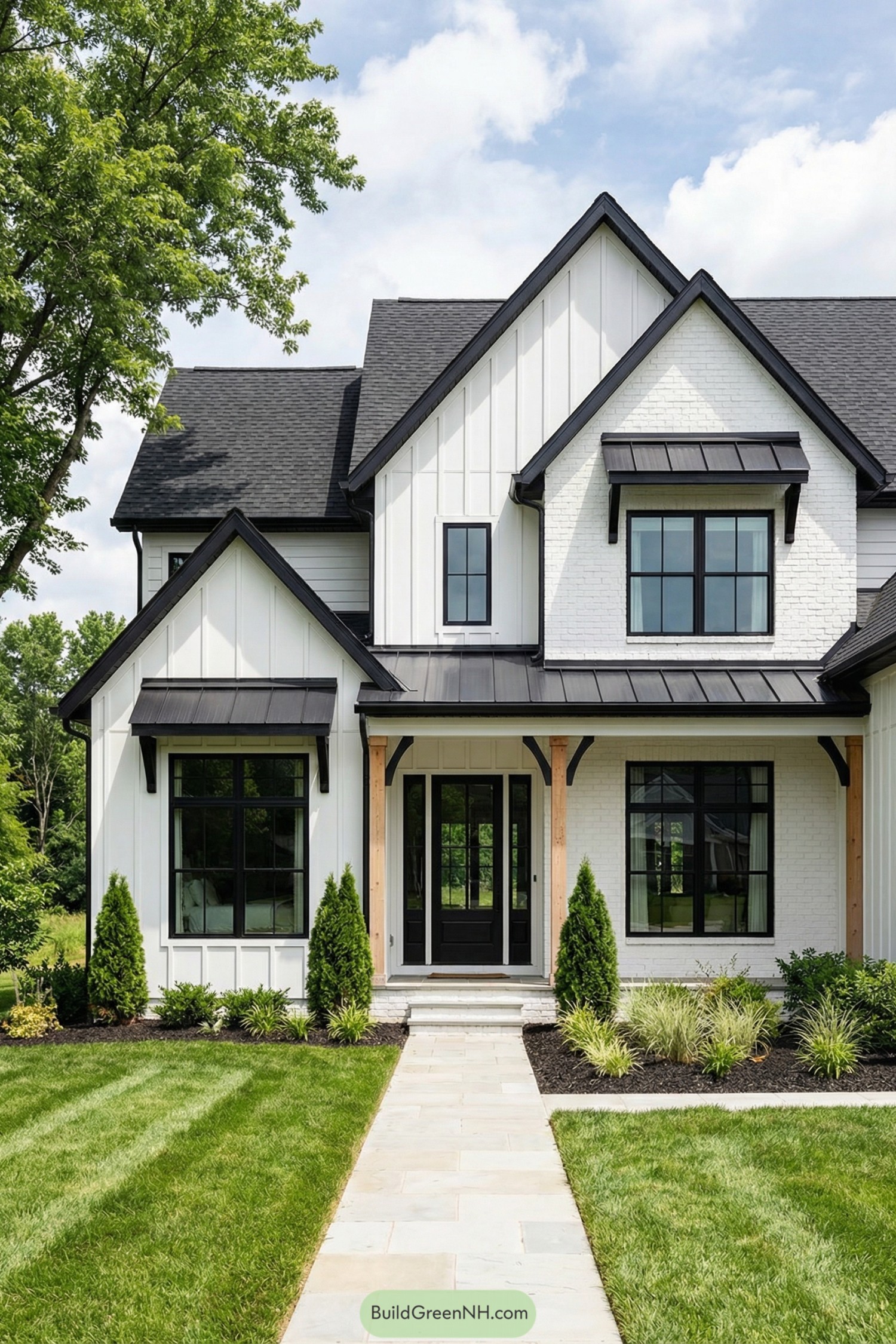 Modern black and white gabled farmhouse exterior with manicured front lawn and stone walkway