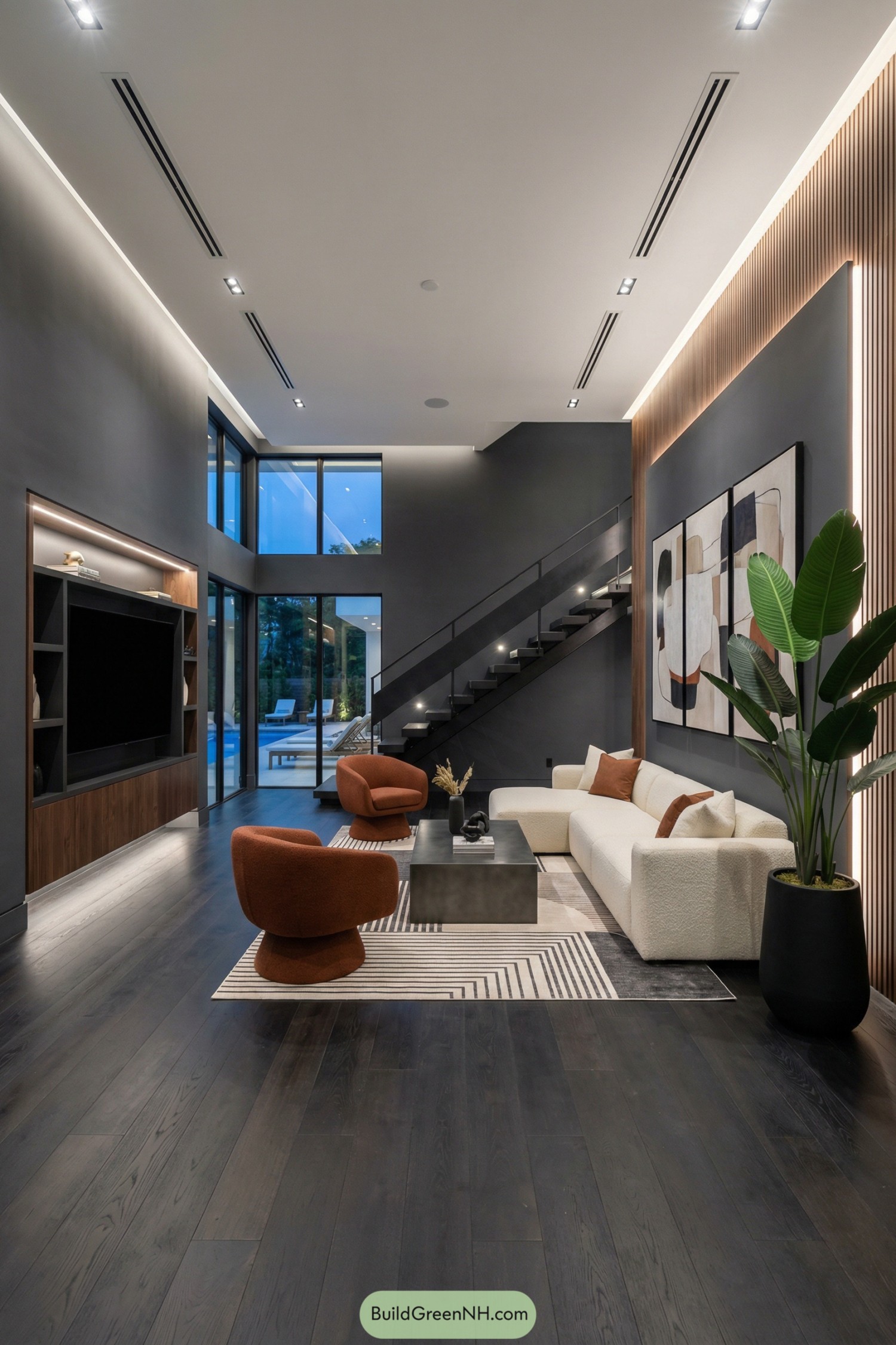 Contemporary double height living room with dark walls, white sectional sofa, rust chairs, and floating metal staircase beside tall glass doors
