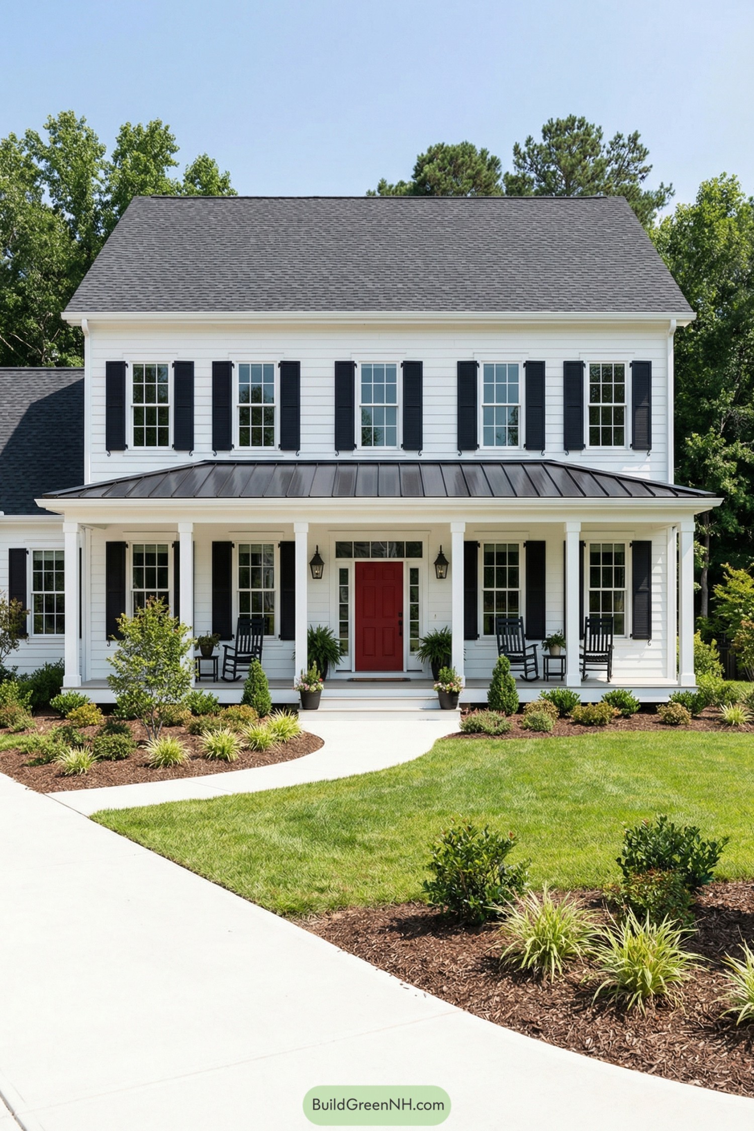 White colonial house with black shutters and a deep front porch featuring a bold red door and rocking chairs