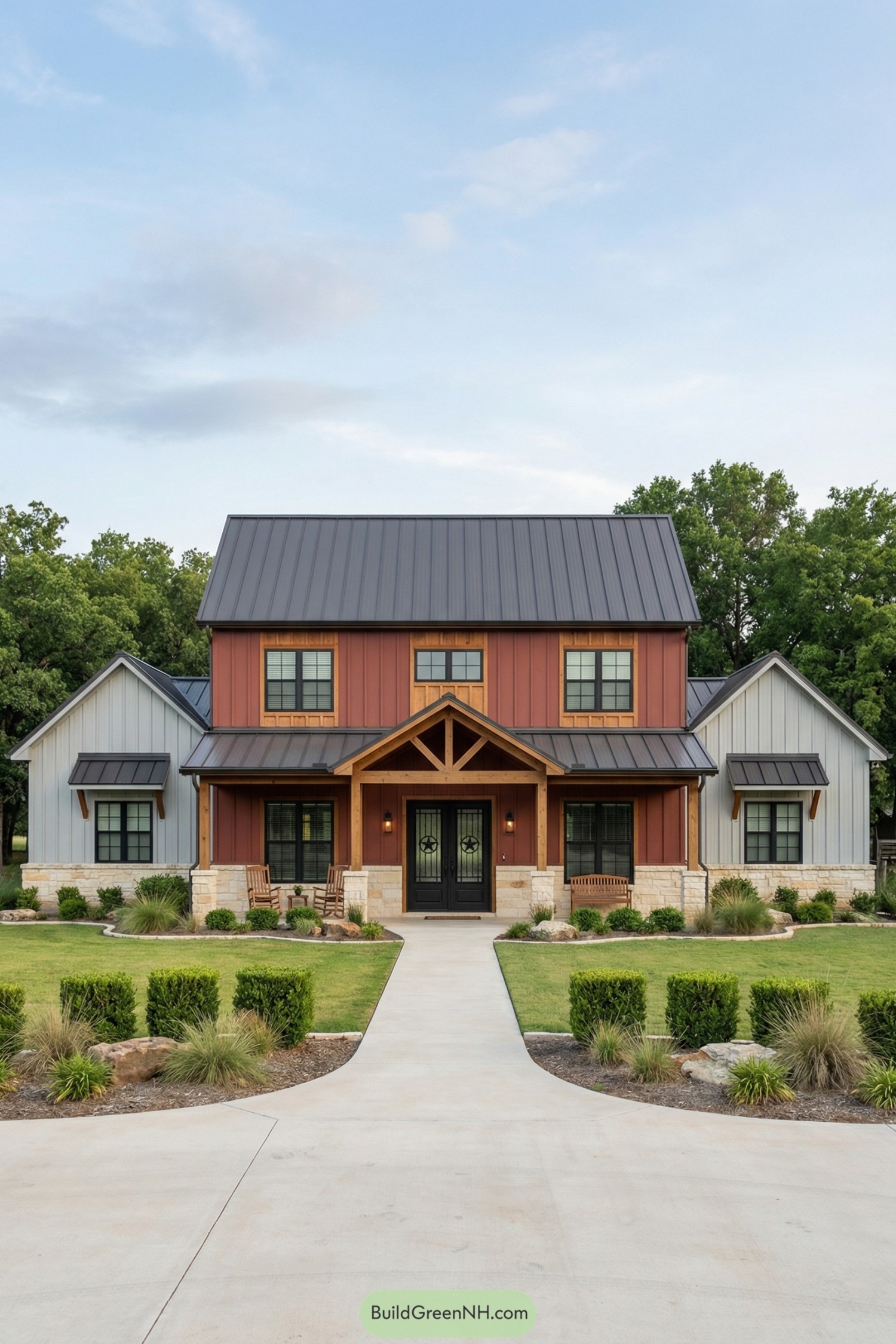 Red and gray colonial barndominium with metal roof and timber front porch framed by neat landscaping