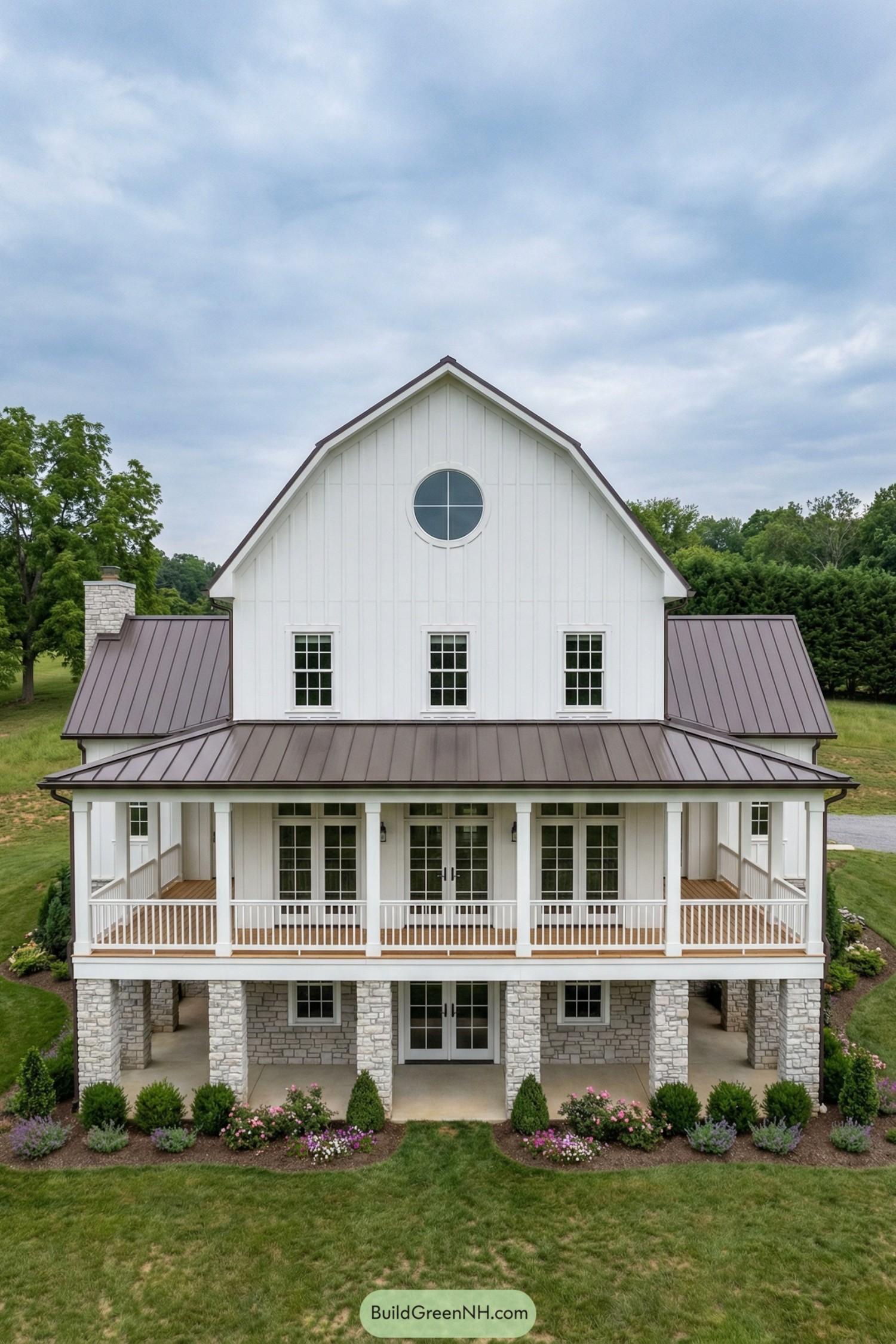 White gambrel barn home with wraparound porch and stone lower level
