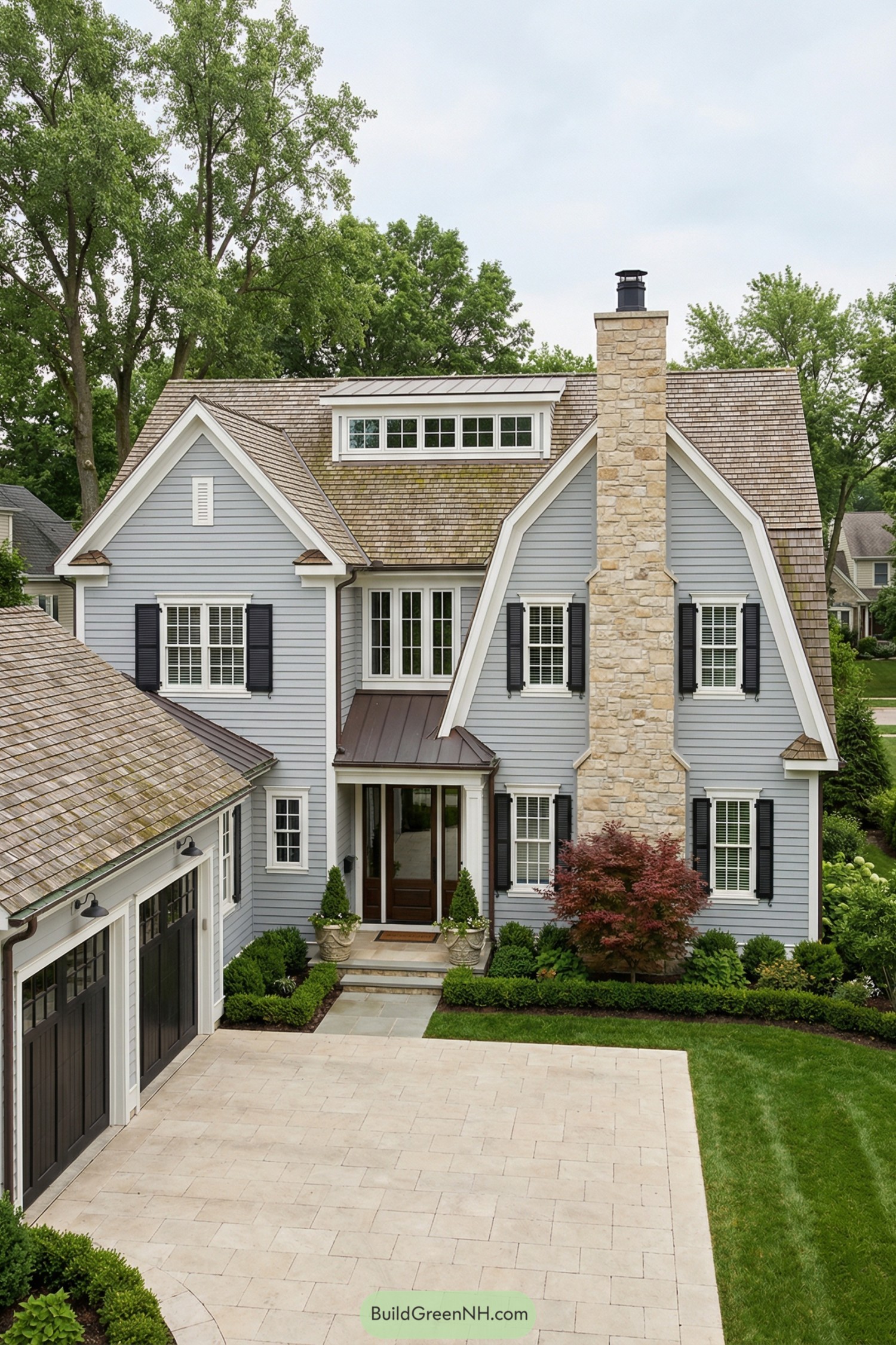 Gray blue colonial home with stone chimney black shutters and tidy landscaping