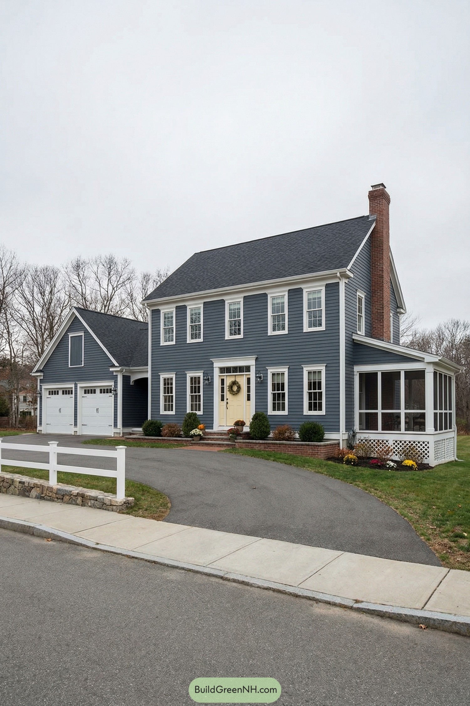Classic blue colonial house with white trim, pale yellow door, and screened side porch