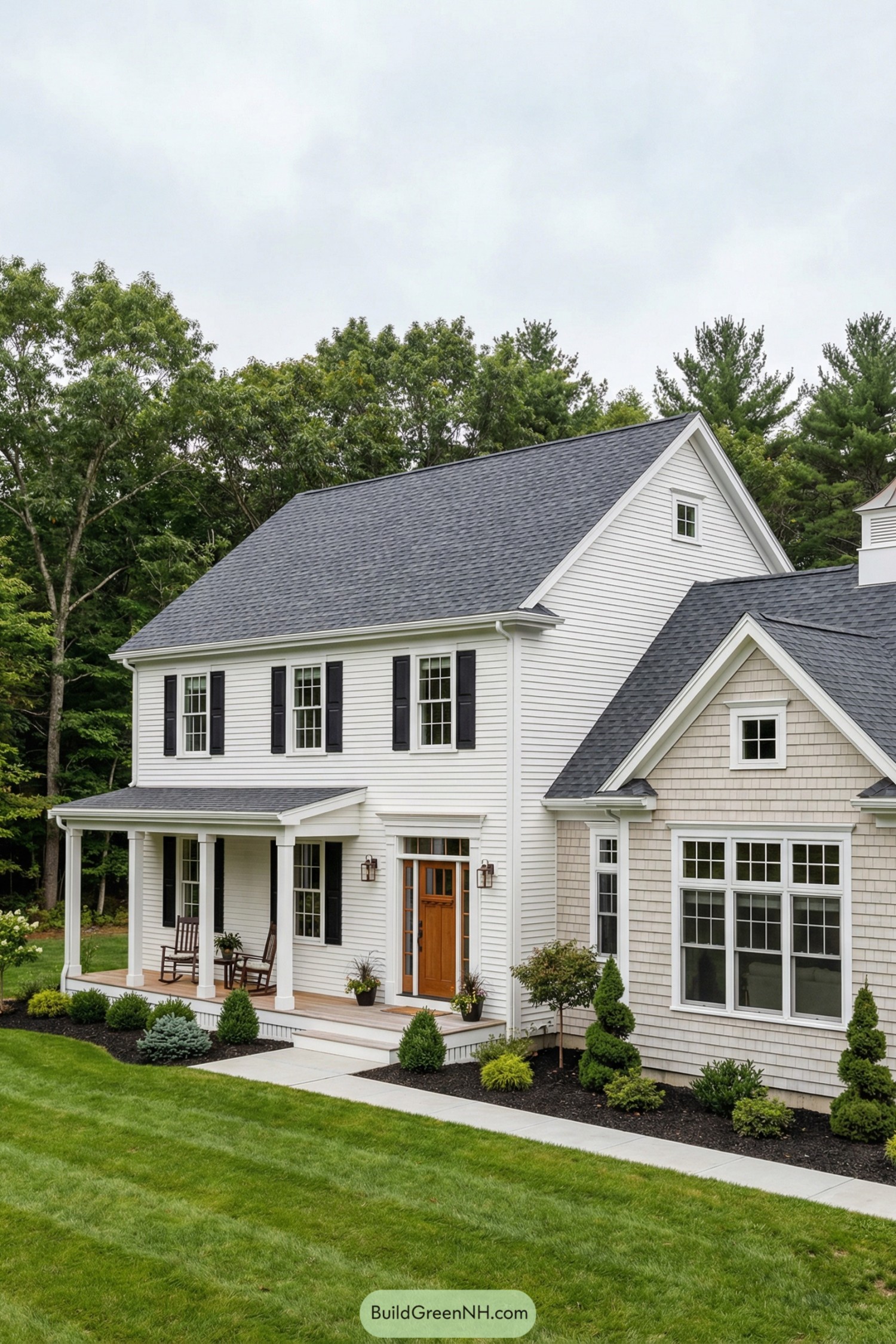 White garrison style home with front porch, black shutters, and attached wing facing a manicured lawn