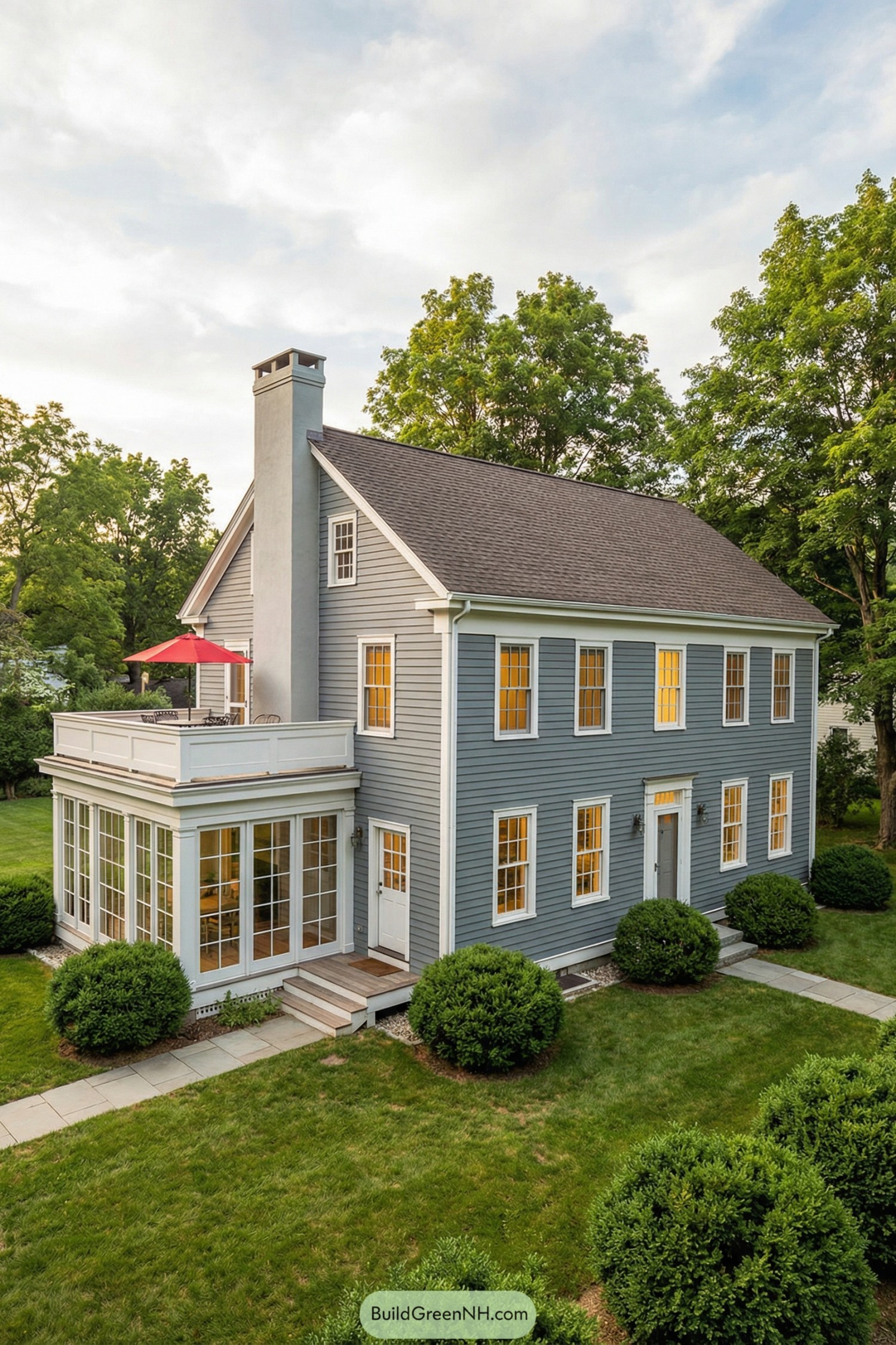 Two story blue garrison colonial home with sunroom and rooftop terrace