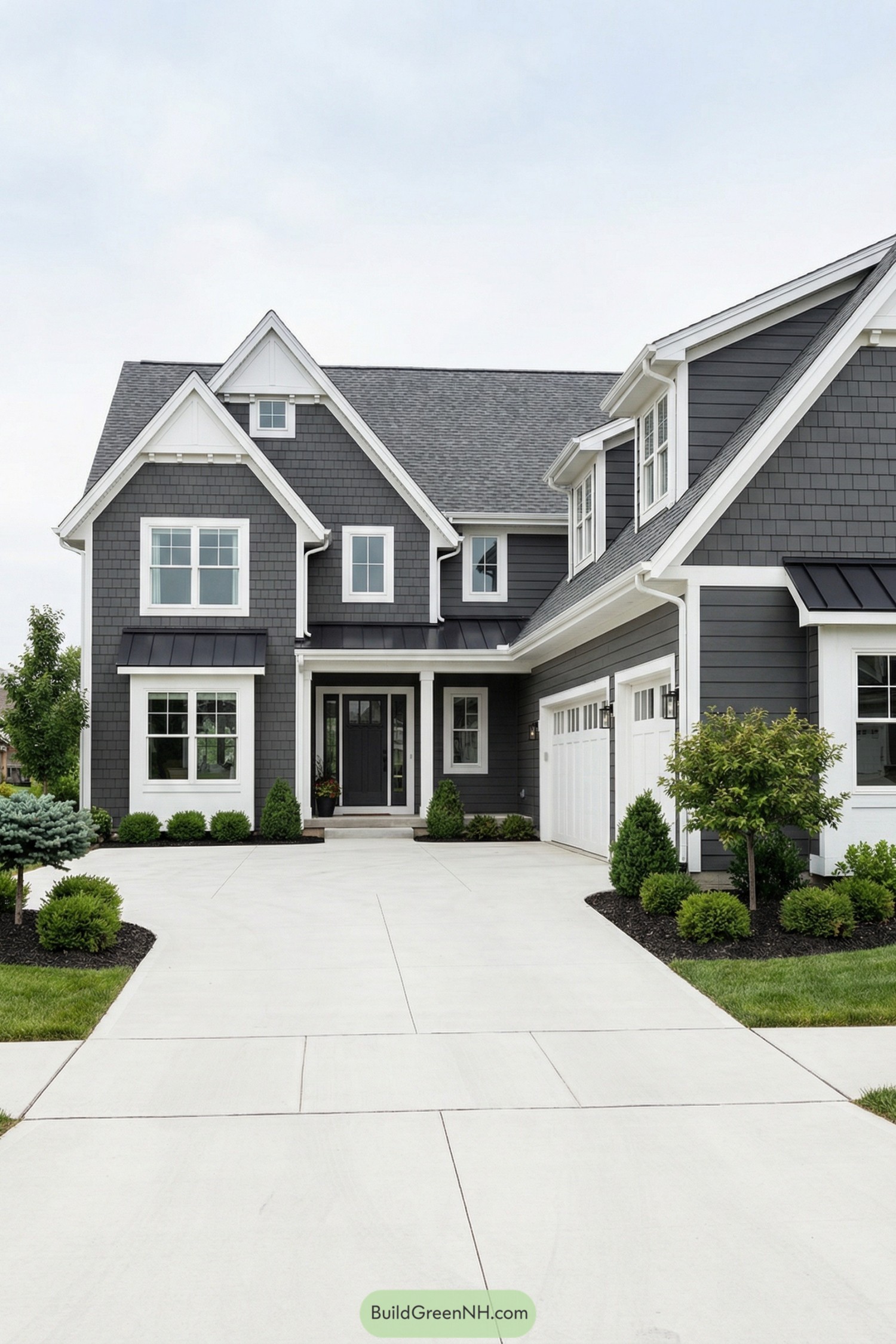 Gray gabled house with white trim and wide concrete driveway
