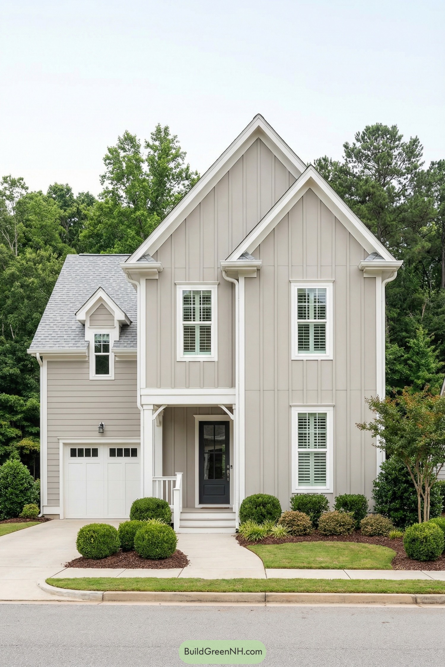 Light gray vertical board and batten house with white trim and a single-car garage, framed by neat shrubs along the front walkway