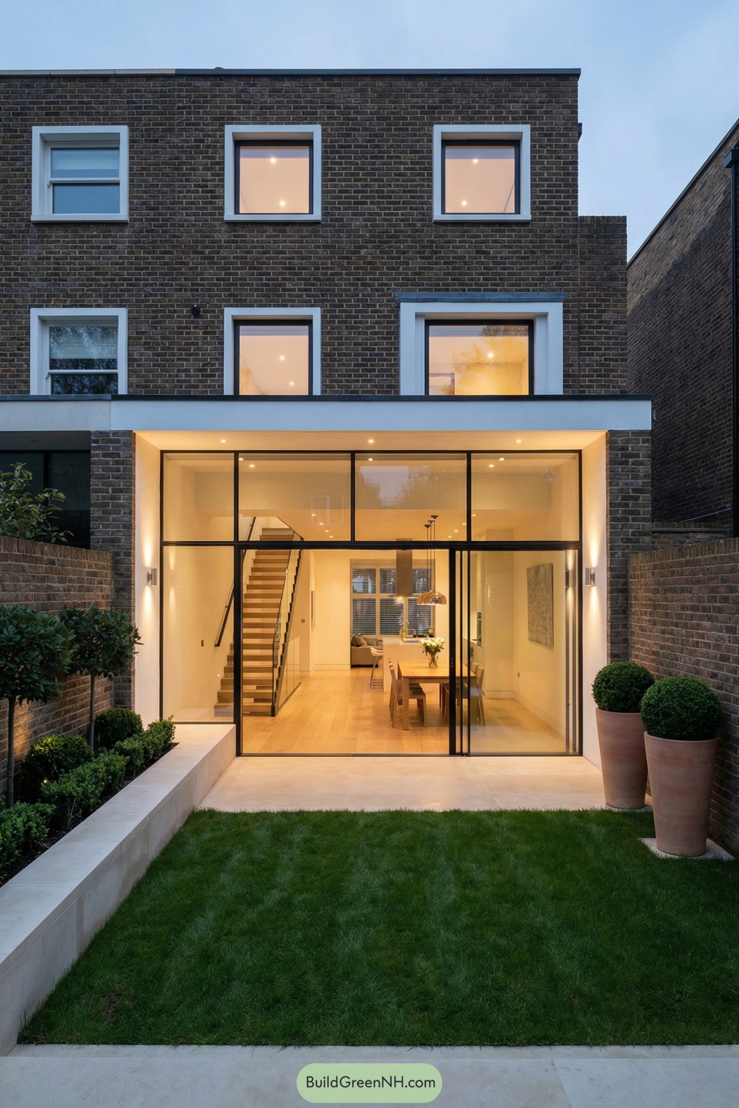 Modern brick townhouse with full-height glass rear extension opening to a small landscaped garden