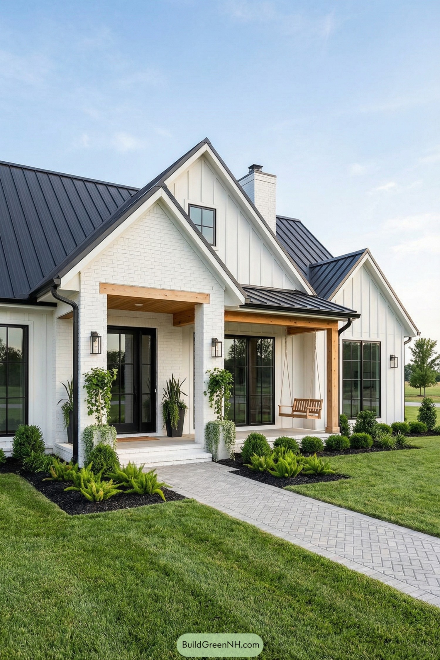 Modern white cottage with black metal roof, wood porch accents, and manicured front garden