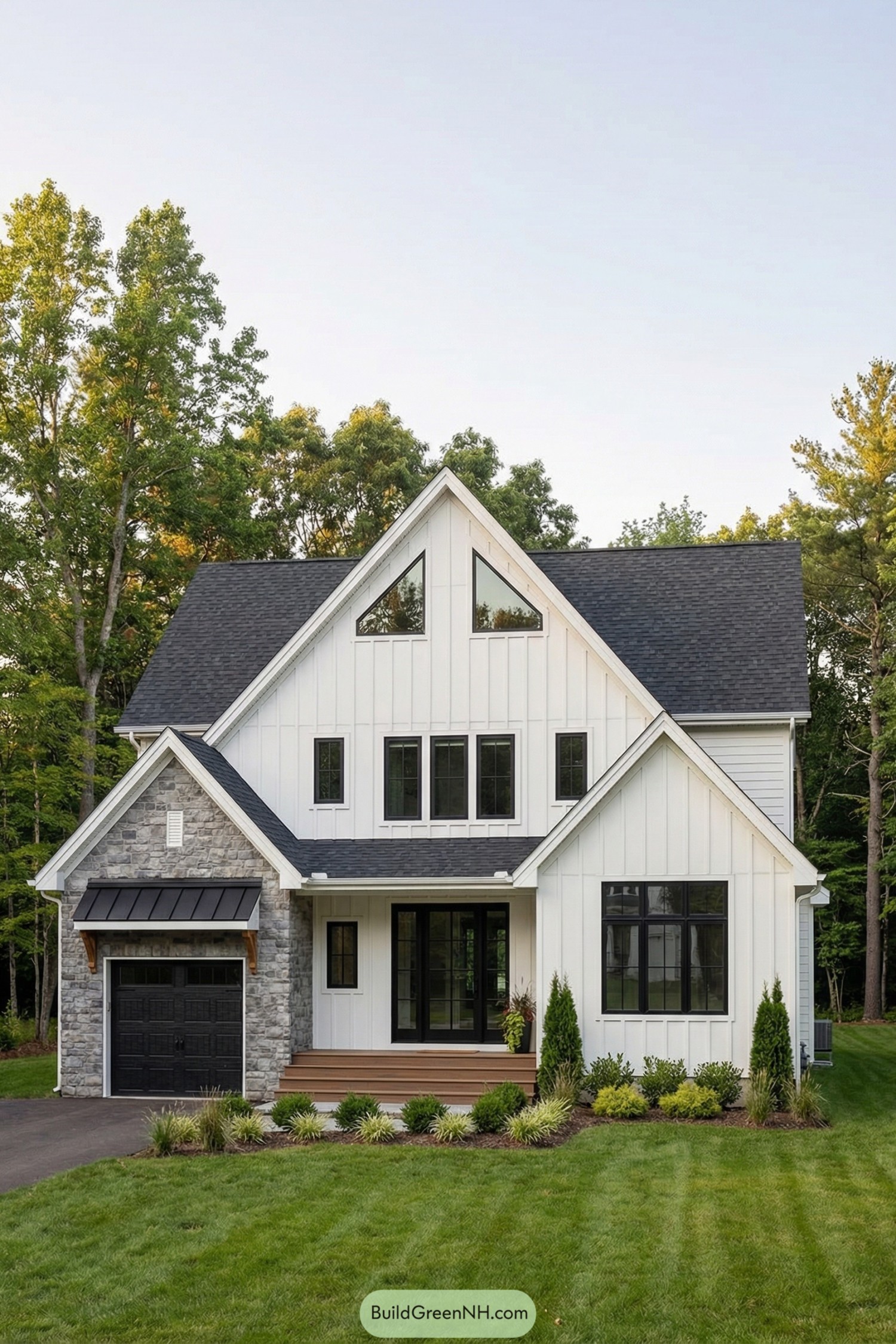 White board and batten cottage with steep gables stone garage and black trim