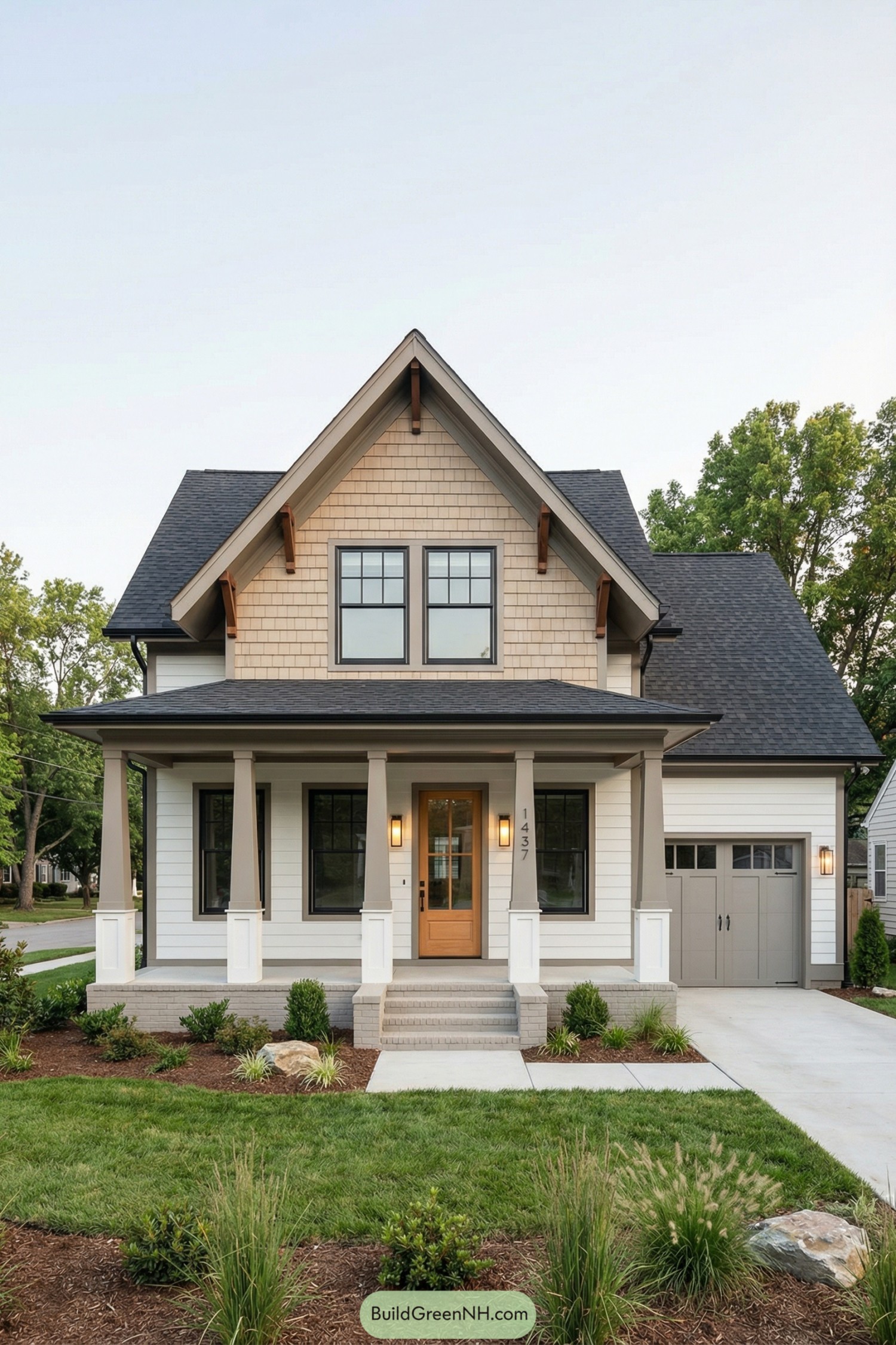 high-res photo of modern craftsman cottage, symmetrical front facade with prominent central front-facing gable over a full-width covered porch, crisp white horizontal lap siding at the lower level and warm beige shingle siding in the upper gable, simple dark trim accents, compact two-story massing with attached side garage extending to the right, dark charcoal asphalt shingle roof with moderate pitch, wide overhangs, exposed decorative brackets under the main gable, black-framed double-hung windows with simple grid muntins and equal proportions, paired upper windows in the gable and evenly spaced tall windows flanking the entry, warm natural-wood front door with clear glass panel and minimal vertical house numbers, sleek rectangular wall sconces in warm metal flanking the door and garage, porch supported by sturdy square tapered columns in muted taupe with white bases set on low solid porch walls, light gray brick steps and walkway leading to the porch, expansive concrete driveway to the right toward the double carriage-style garage doors in soft gray with simple recessed panels and small upper glass lites, front landscaping with fresh mulch beds, ornamental grasses, low shrubs, a few accent boulders, neatly edged green lawn in the foreground, quiet suburban street setting with neighboring houses on each side and mature leafy trees in the background, clear soft sky with gentle daylight creating clean, picture-worthy composition. single real-life photo, high-resolution, architectural photography, soft lighting, cinematic composition, strictly no collages