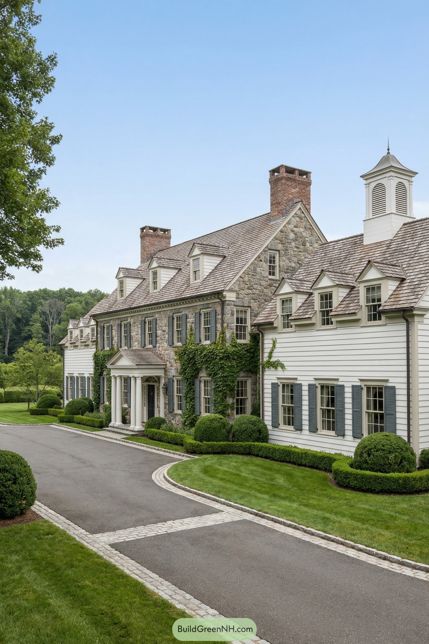 Grand country estate with stone facade, white siding, and ivy framed windows along a curved drive