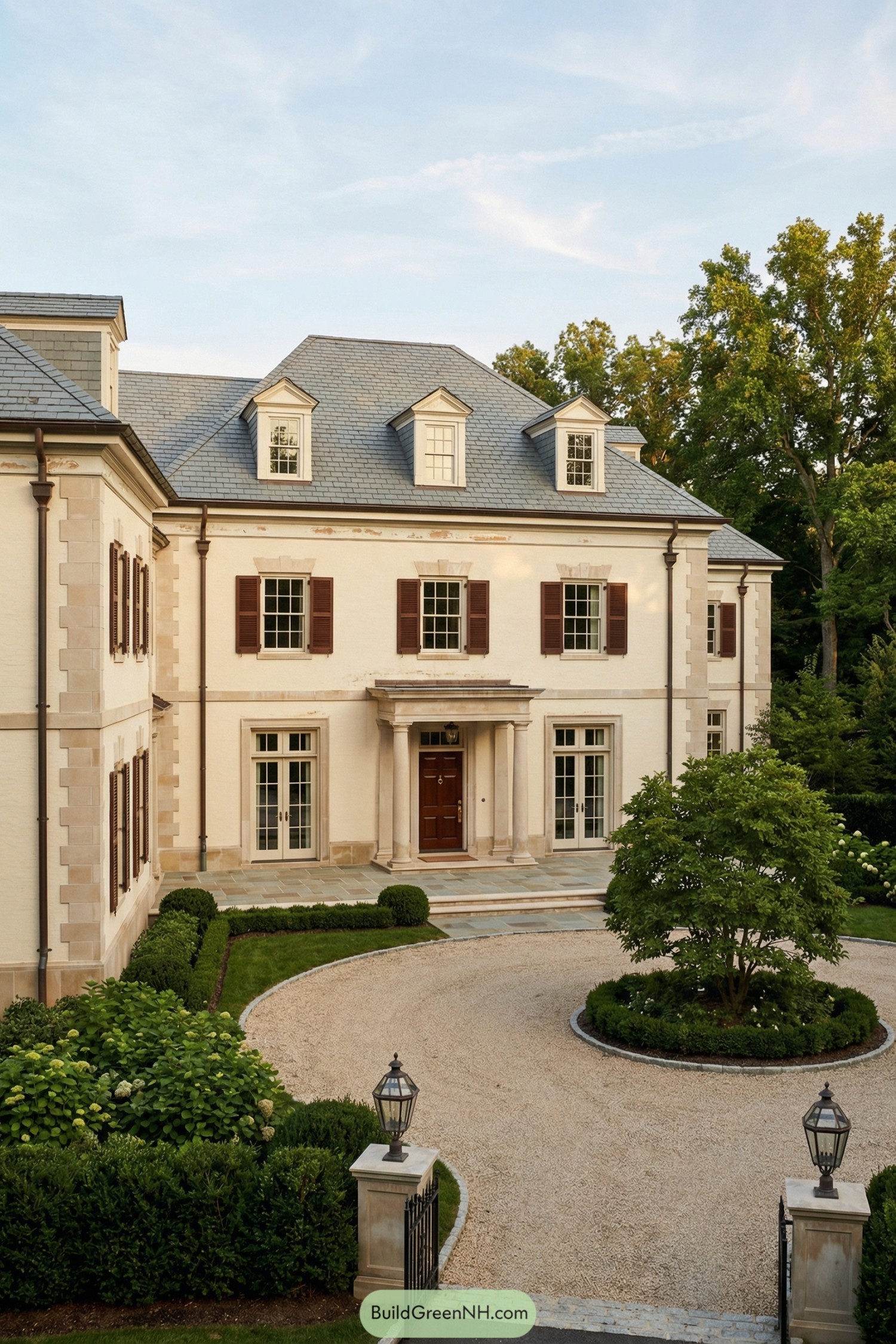 Elegant cream manor with slate roof, dormers, and circular gravel drive