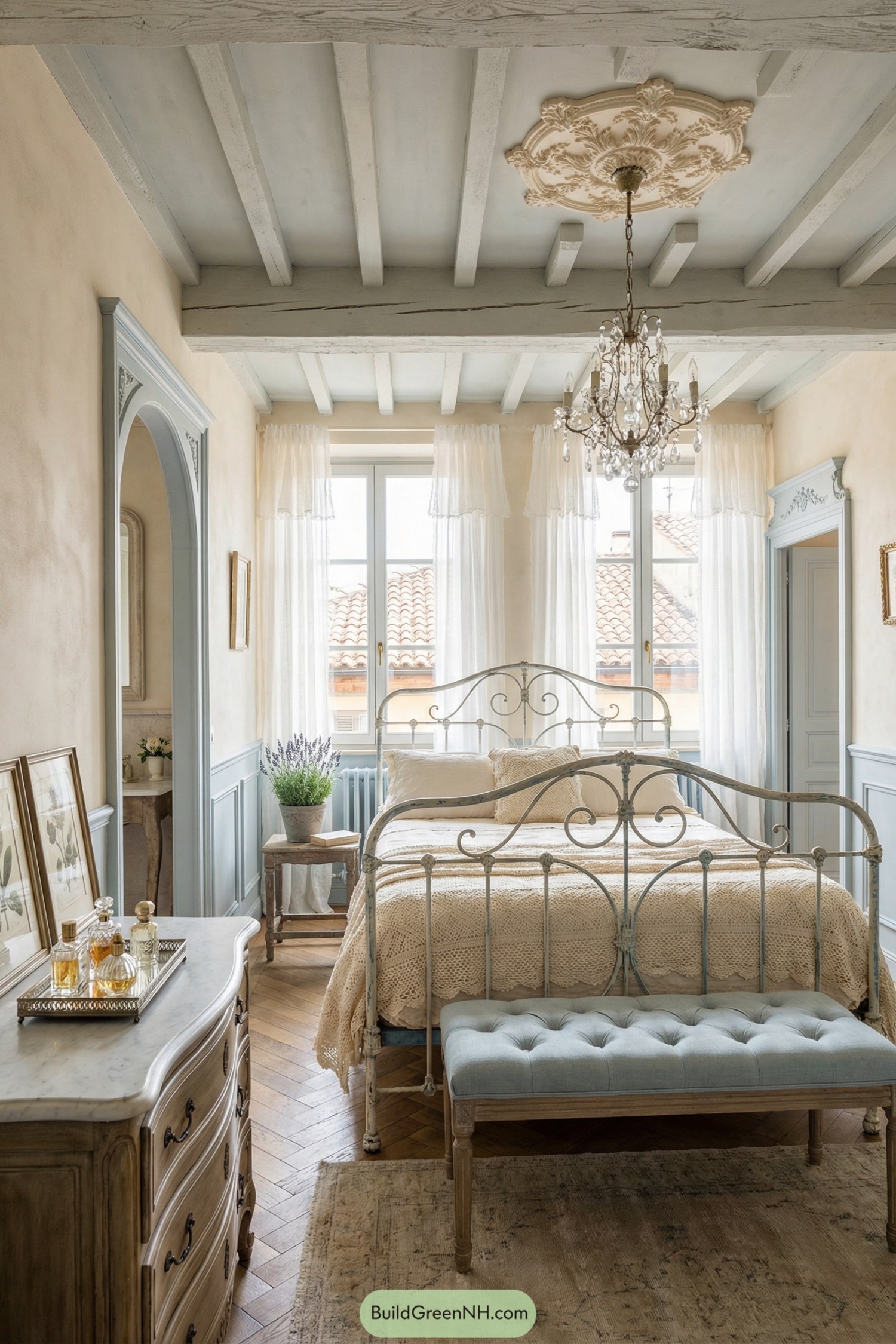 Elegant shabby chic bedroom with iron bed chandelier and soft pastel finishes