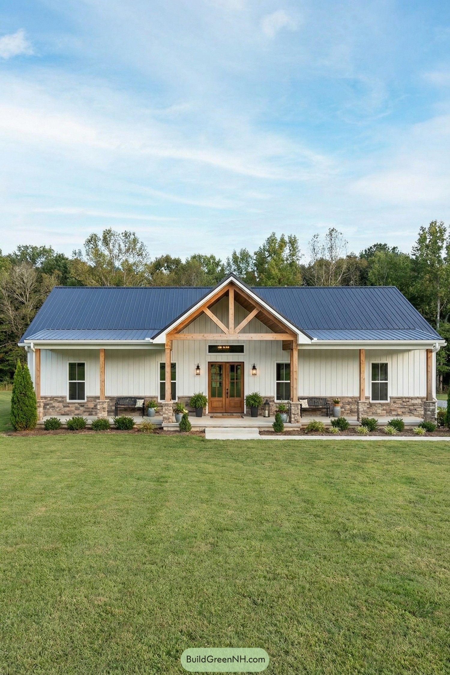 Single story barndominium with blue metal roof, wood posts, and stone accents across a wide front porch
