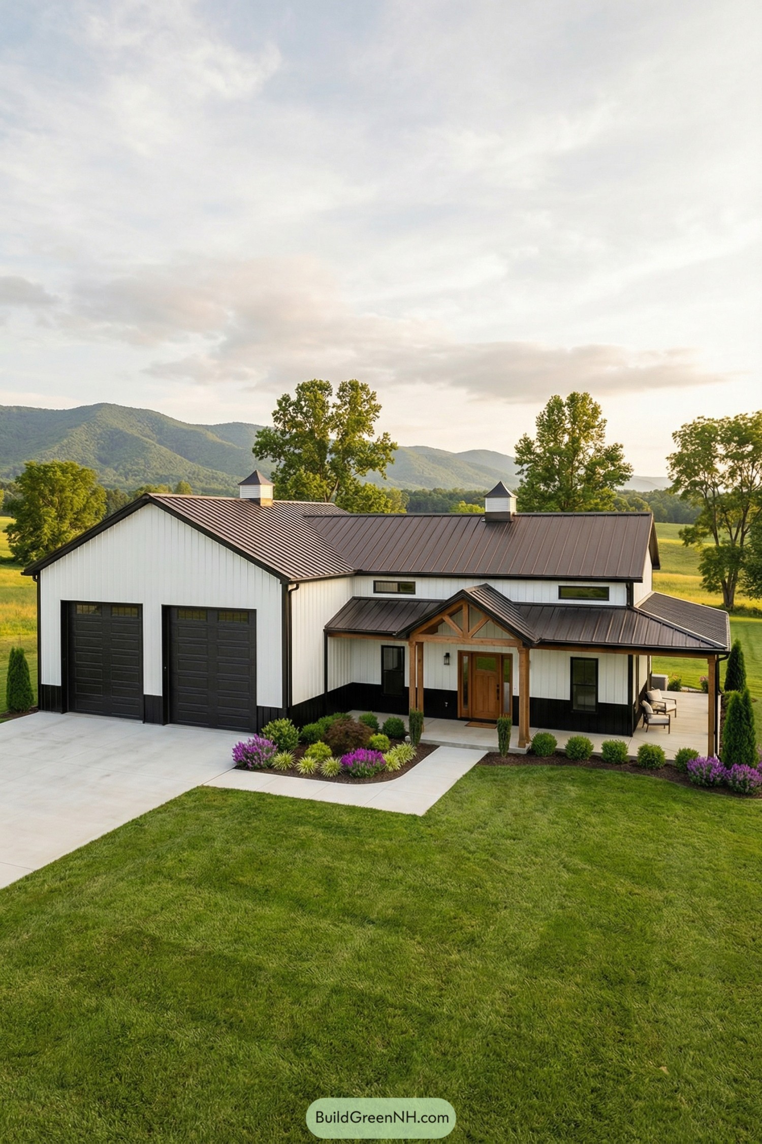 White and black single story barndominium with twin garage doors and covered porch