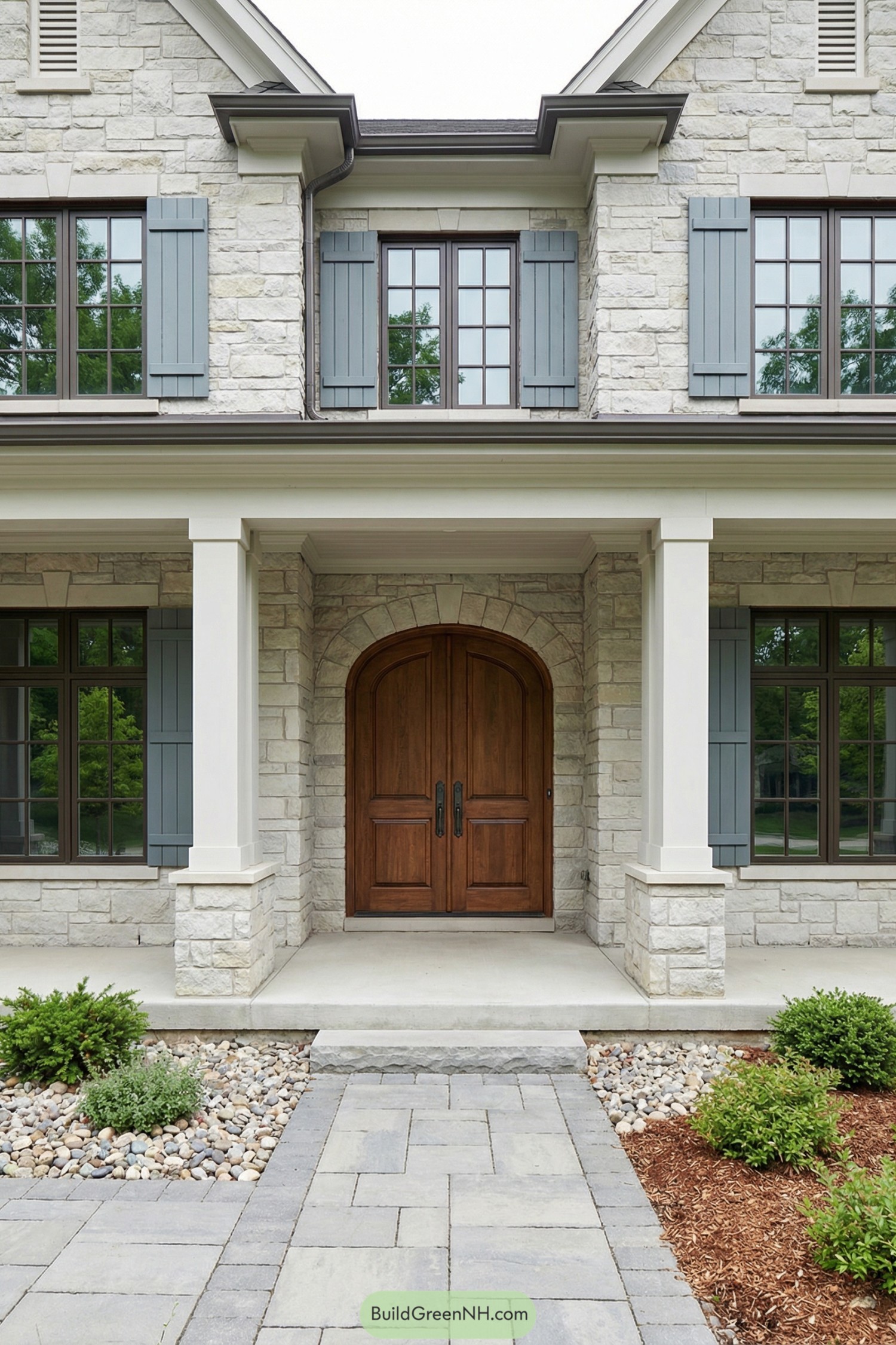 Light stone house with wood arched doorway and blue shutters