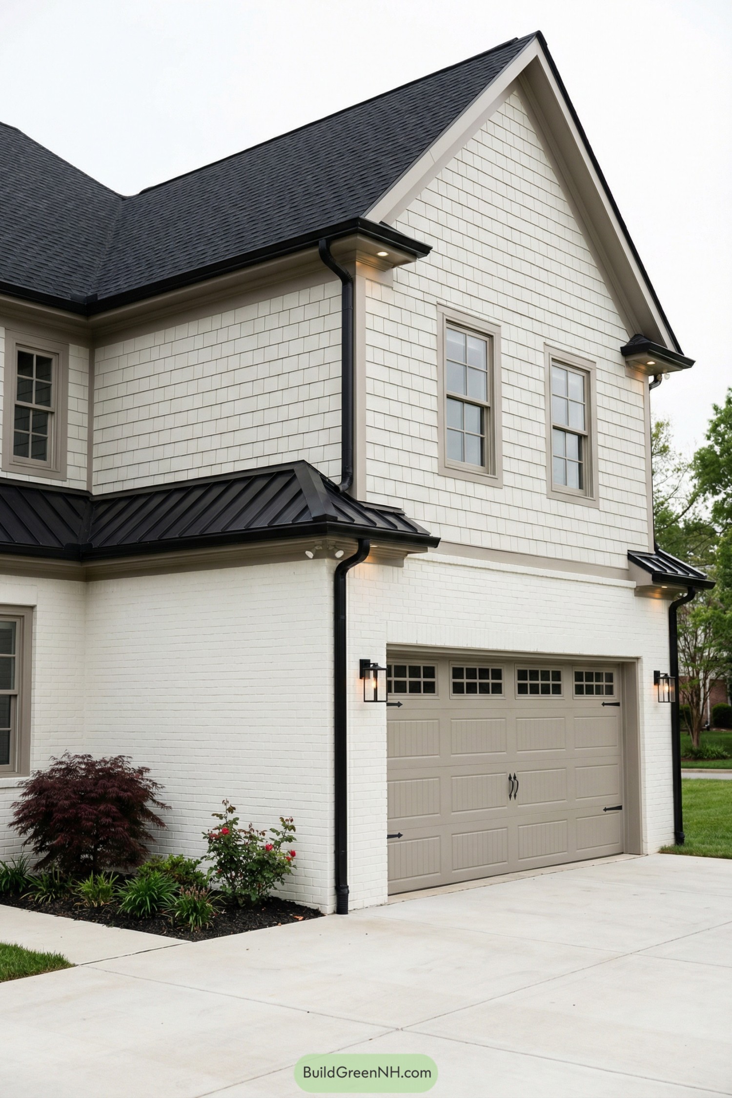 Cream brick and shingle sided house corner with taupe garage door and black shingle roof