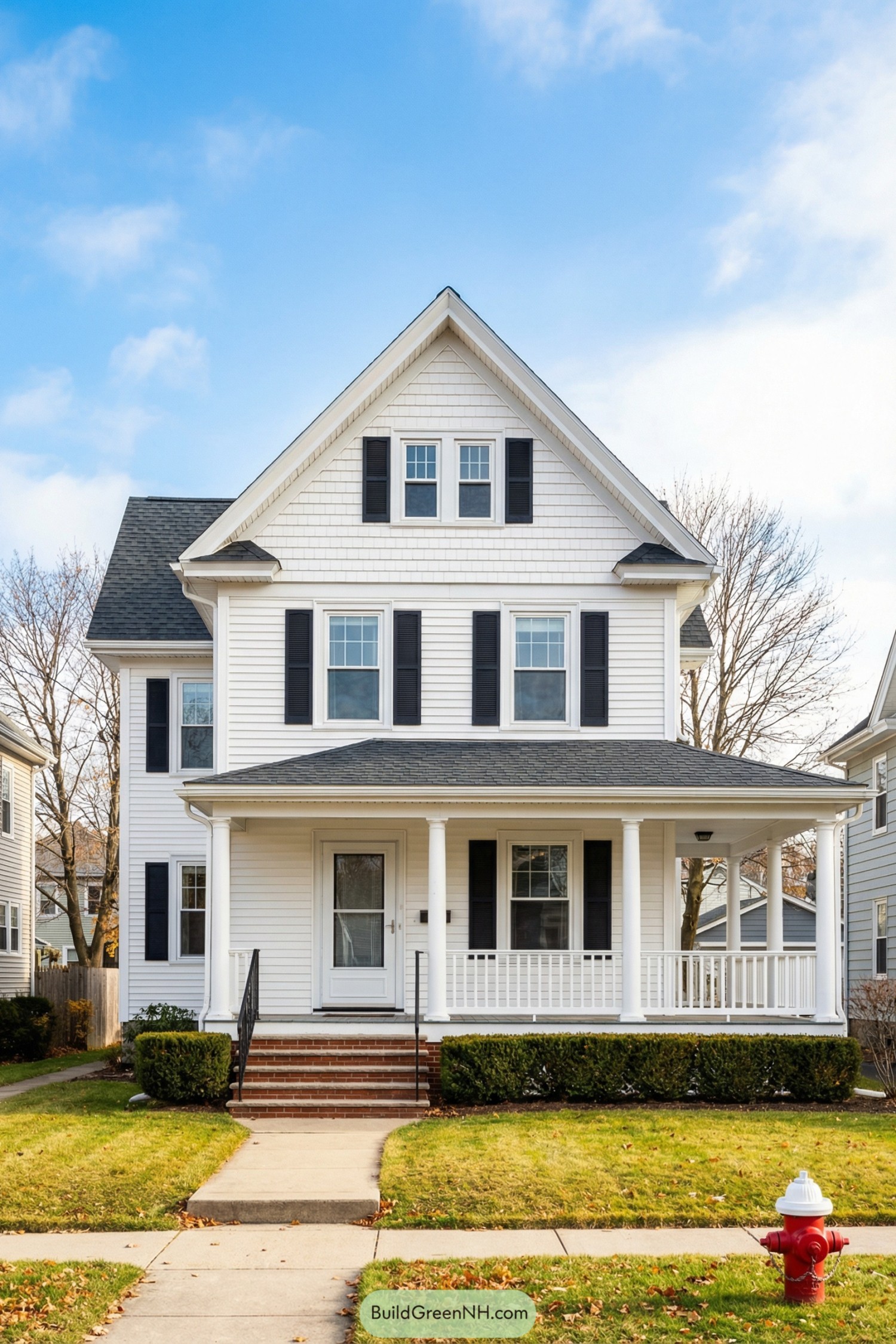 White two story gabled house with black shutters and a wraparound porch