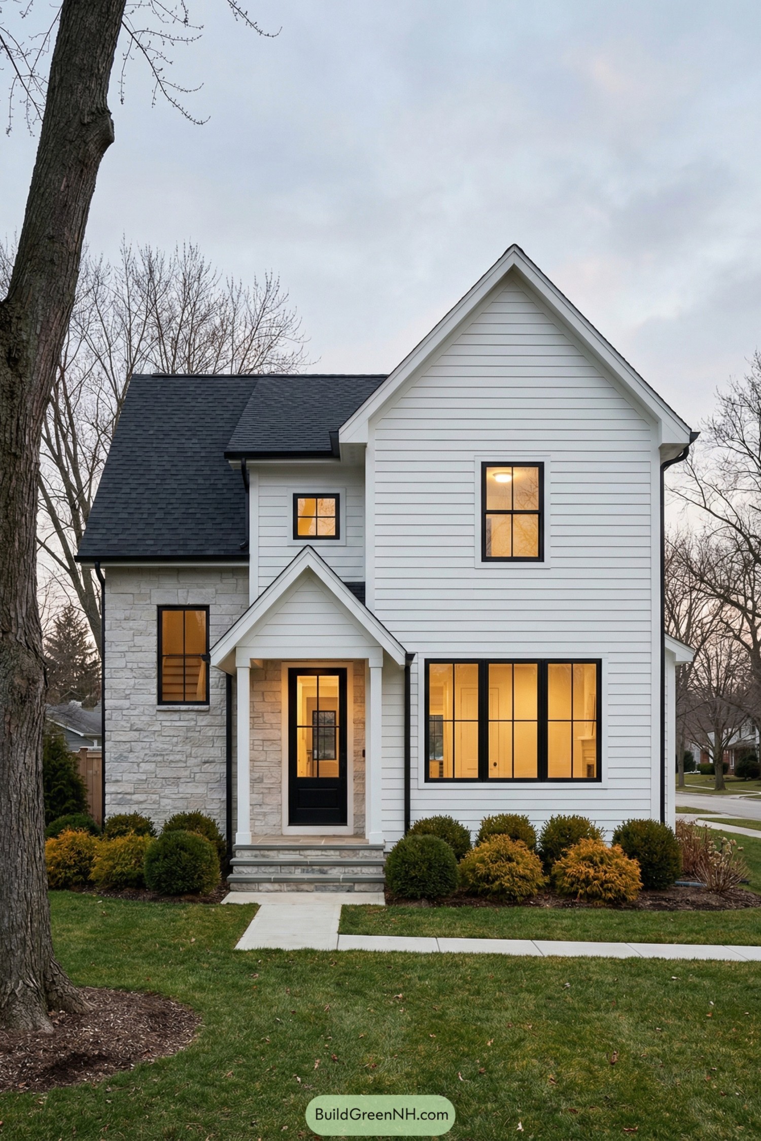White modern farmhouse with black windows and stone accent wall at front entry