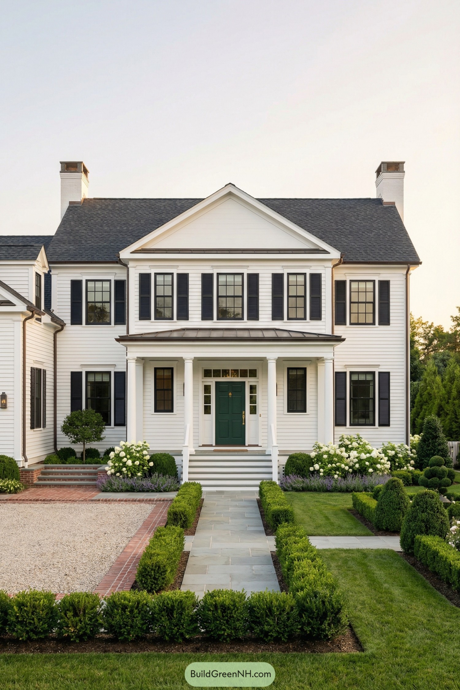 White colonial style home with dark shutters and manicured front garden leading to a central porch