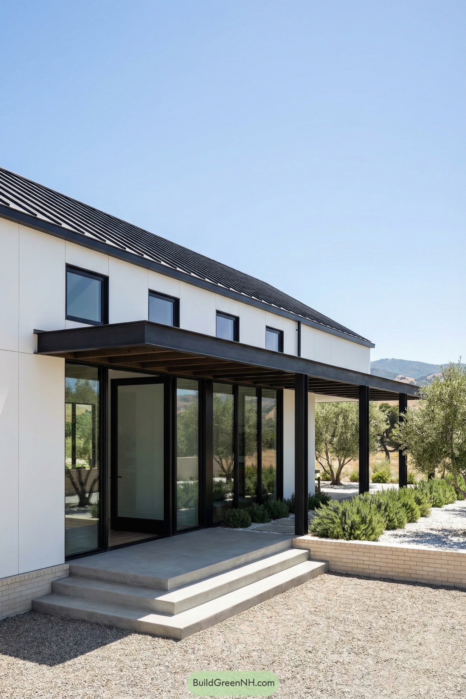 Modern ranch barndominium with black steel porch, large glass doors, and minimalist landscaping