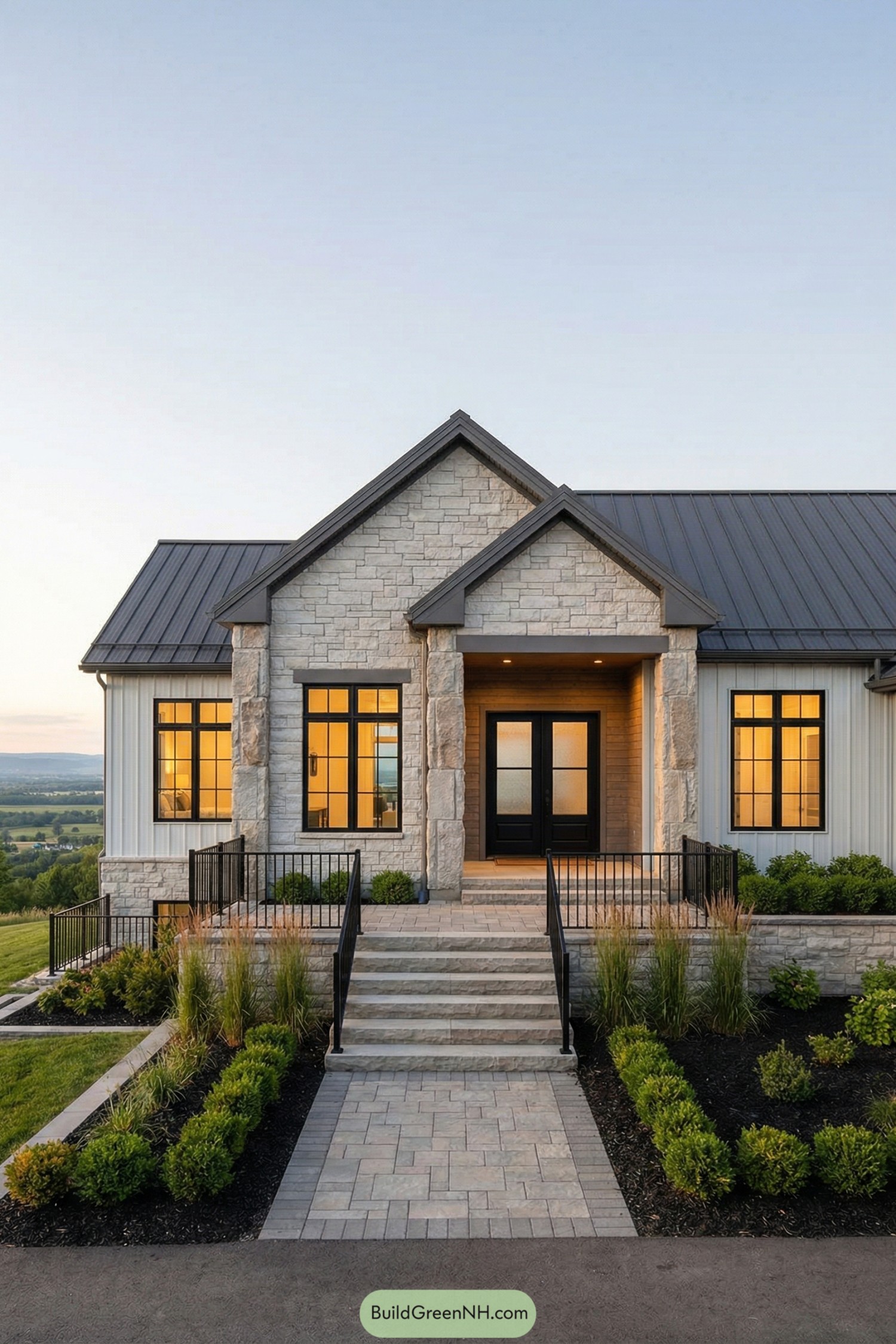 Modern ranch barndominium with stone facade, metal roof, and landscaped stepped walkway leading to a double-door entry